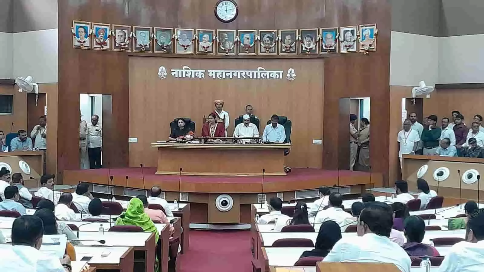 नासिक महानगरपालिका के मंच पर बैठी महापौर और अन्य अधिकारी बैठक संचालित कर रहे हैं। नासिक महानगरपालिका के मंच पर बैठी महापौर और अन्य अधिकारी बैठक संचालित कर रहे हैं।