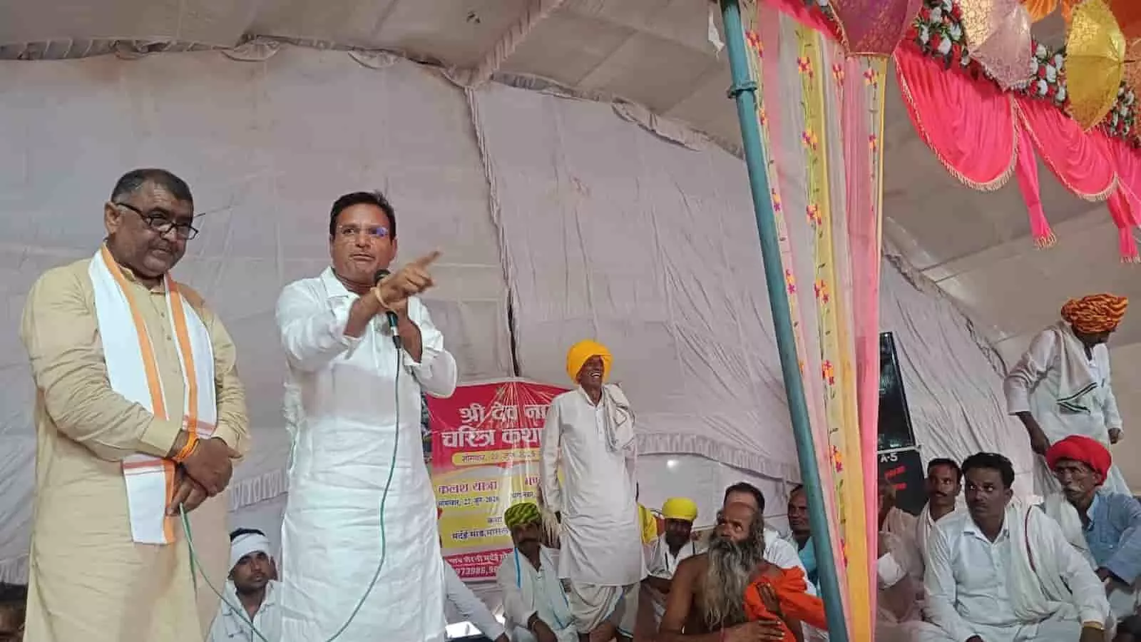 श्री देवनारायण कथा के मंच पर संबोधित करते राजाराम गुर्जर और बैठे हुए श्रद्धालु। श्री देवनारायण कथा के मंच पर संबोधित करते राजाराम गुर्जर और बैठे हुए श्रद्धालु।