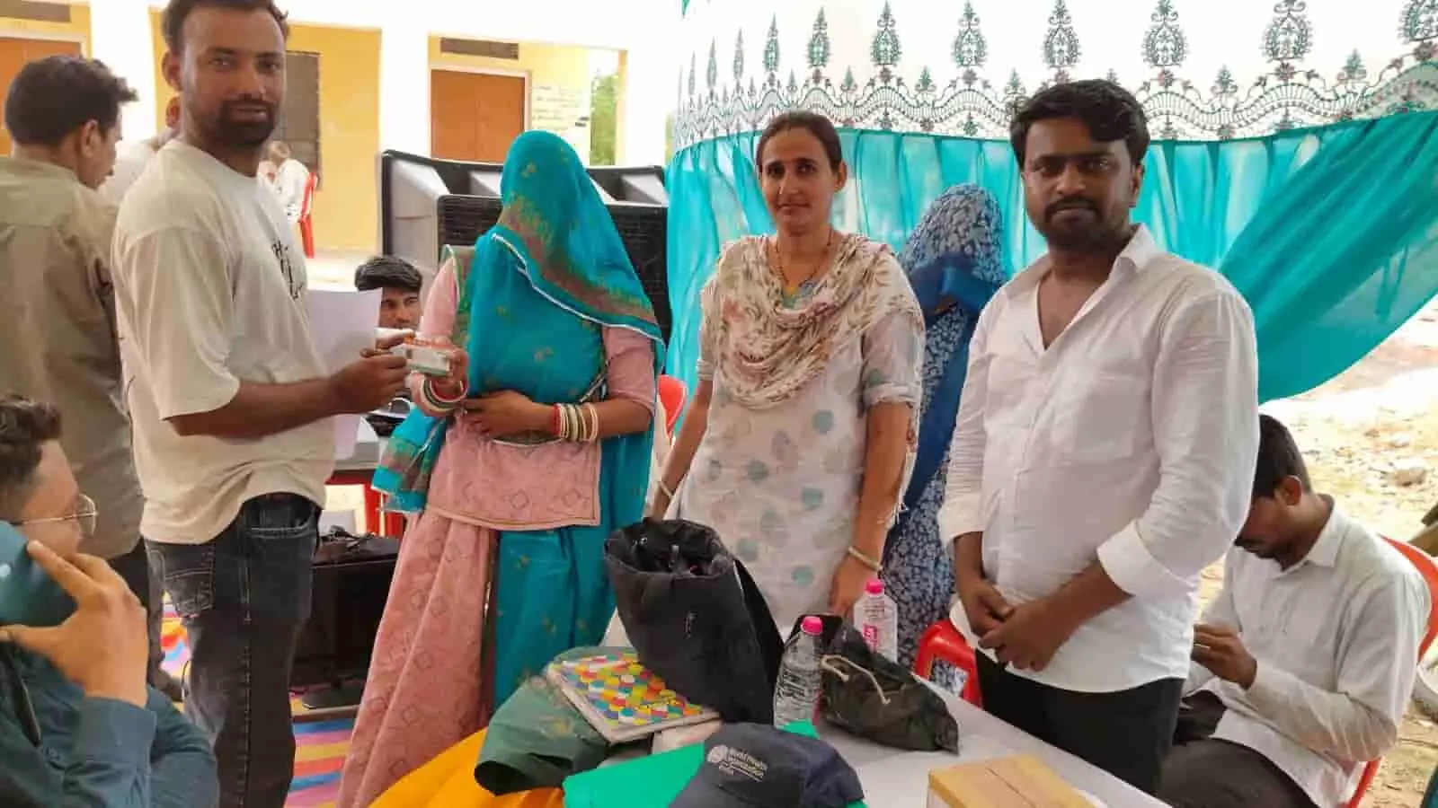 स्वास्थ्य सेवा शिविर में एक महिला लाभार्थी को कार्ड वितरित करते हुए विभागीय कर्मी। स्वास्थ्य सेवा शिविर में एक महिला लाभार्थी को कार्ड वितरित करते हुए विभागीय कर्मी।