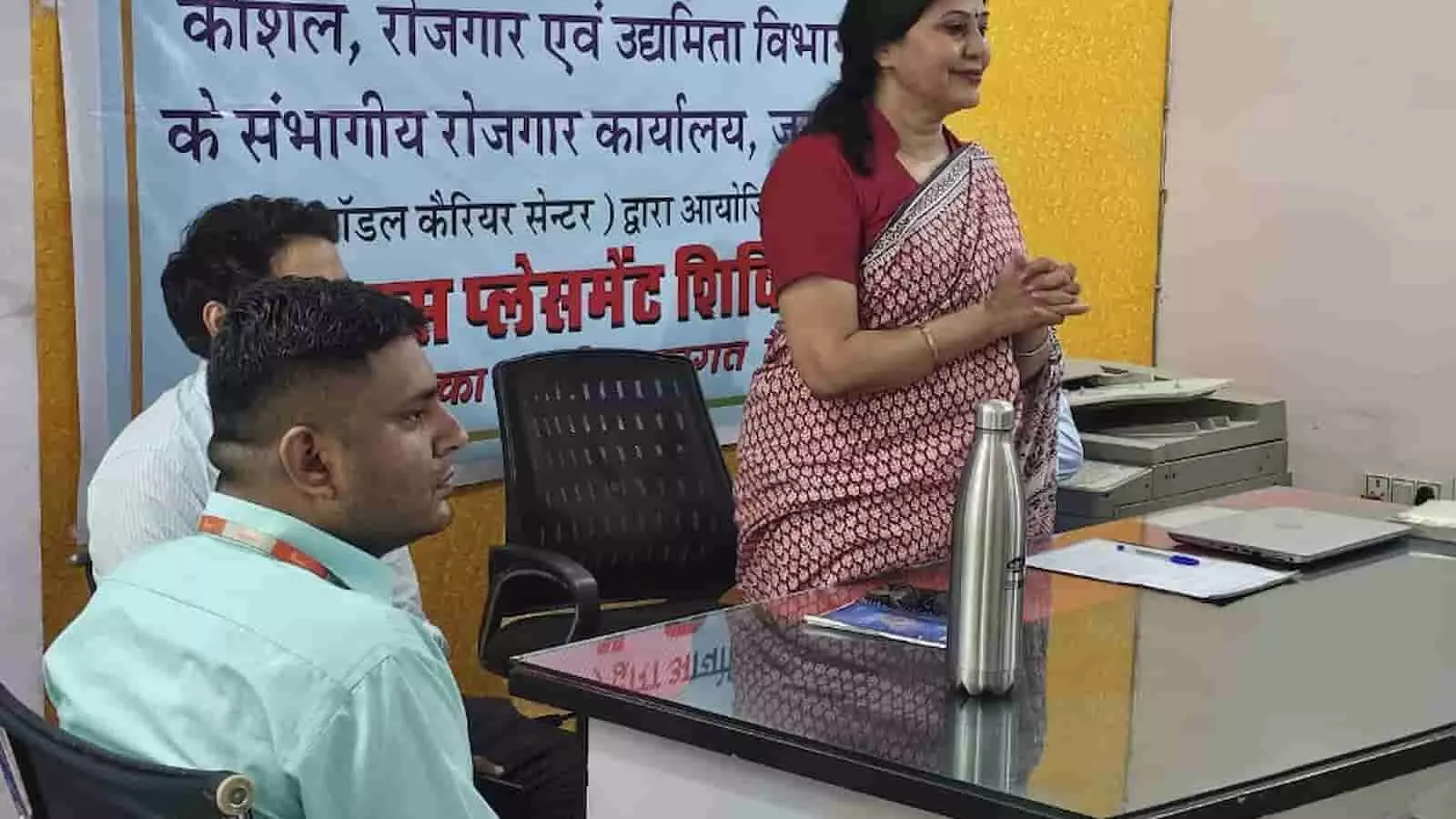 तस्वीर में संभागीय रोजगार कार्यालय के कार्यालय कक्ष में टेबल के पास खड़े और बैठे लोग दिख रहे हैं। तस्वीर में संभागीय रोजगार कार्यालय के कार्यालय कक्ष में टेबल के पास खड़े और बैठे लोग दिख रहे हैं।
