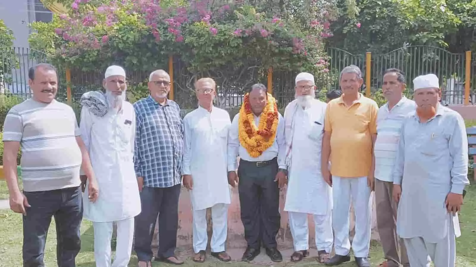 तस्वीर में नेहरू गार्डन में फूलों की माला पहने डॉ. फखरुद्दीन मंसूरी के साथ अन्य लोग खड़े हैं।