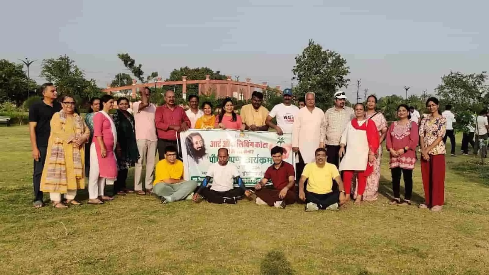 पार्क में आर्ट ऑफ लिविंग के स्वयंसेवक एक बैनर के साथ खड़े हैं। पार्क में आर्ट ऑफ लिविंग के स्वयंसेवक एक बैनर के साथ खड़े हैं।