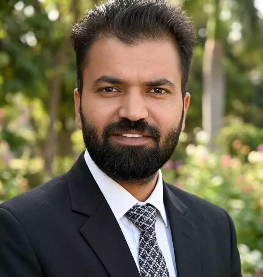 तस्वीर में मानसिंह मेघवाल कोट और टाई पहने हुए मुस्कुराते नजर आ रहे हैं। तस्वीर में मानसिंह मेघवाल कोट और टाई पहने हुए मुस्कुराते नजर आ रहे हैं।
