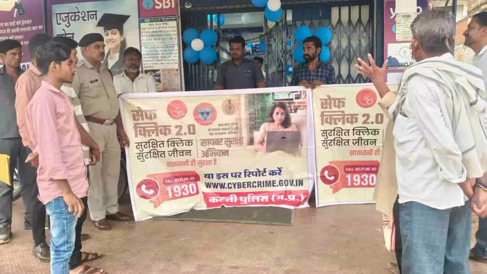 रीठी में पुलिसकर्मी बैंक के सामने नागरिकों को साइबर सुरक्षा अभियान के बारे में बता रहे हैं।