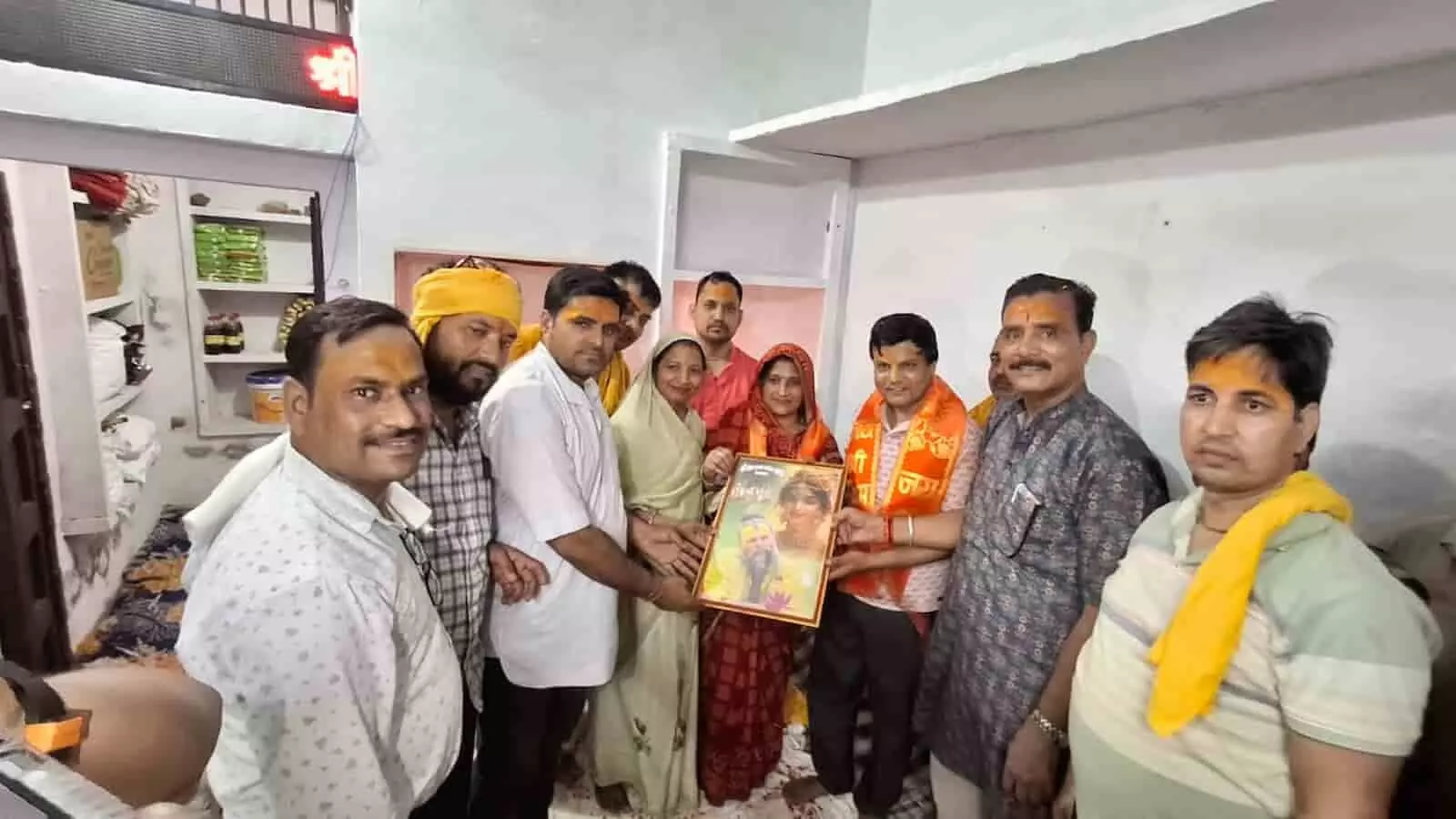 भजन संध्या कार्यक्रम के दौरान धार्मिक चित्र पकड़े हुए पुरुष और महिलाएं। भजन संध्या कार्यक्रम के दौरान धार्मिक चित्र पकड़े हुए पुरुष और महिलाएं।