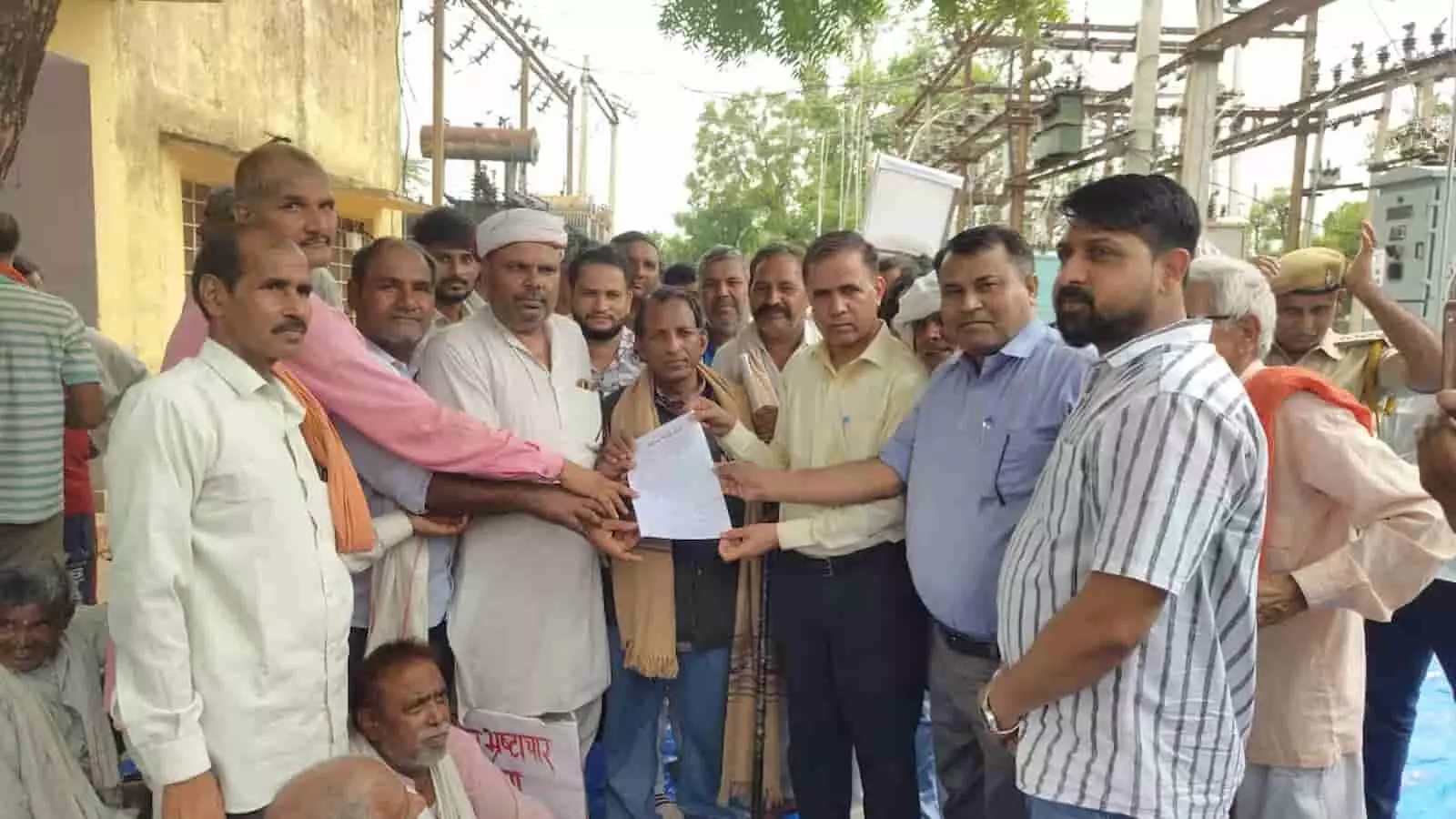 तस्वीर में बिजलीघर परिसर के बाहर ग्रामीण और बिजली विभाग के अधिकारी ज्ञापन सौंपते हुए दिख रहे हैं। तस्वीर में बिजलीघर परिसर के बाहर ग्रामीण और बिजली विभाग के अधिकारी ज्ञापन सौंपते हुए दिख रहे हैं।