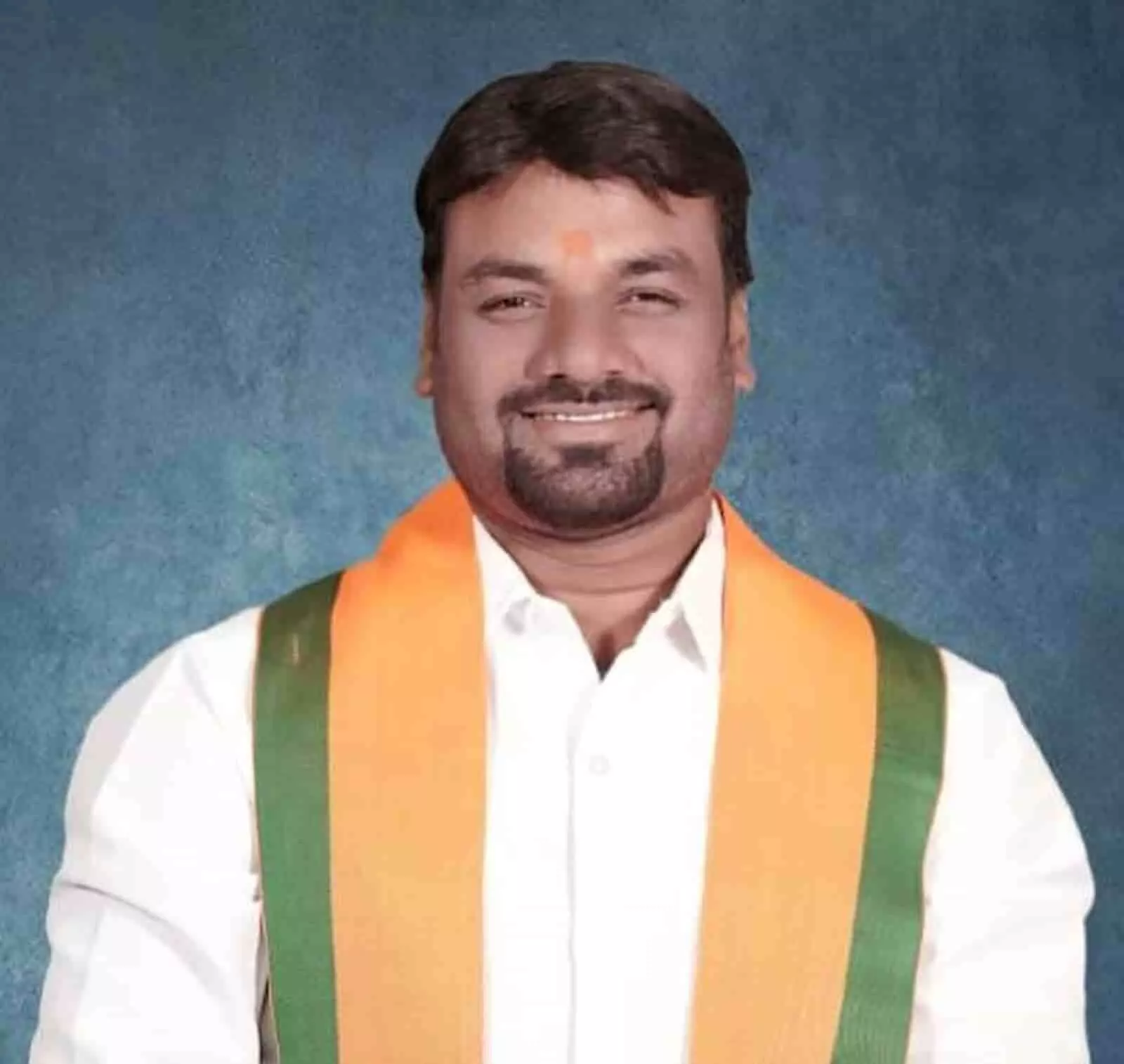 तस्वीर में गडचांदूर के नगरसेवक सूरज पांडे नीले बैकग्राउंड के सामने खड़े हैं।