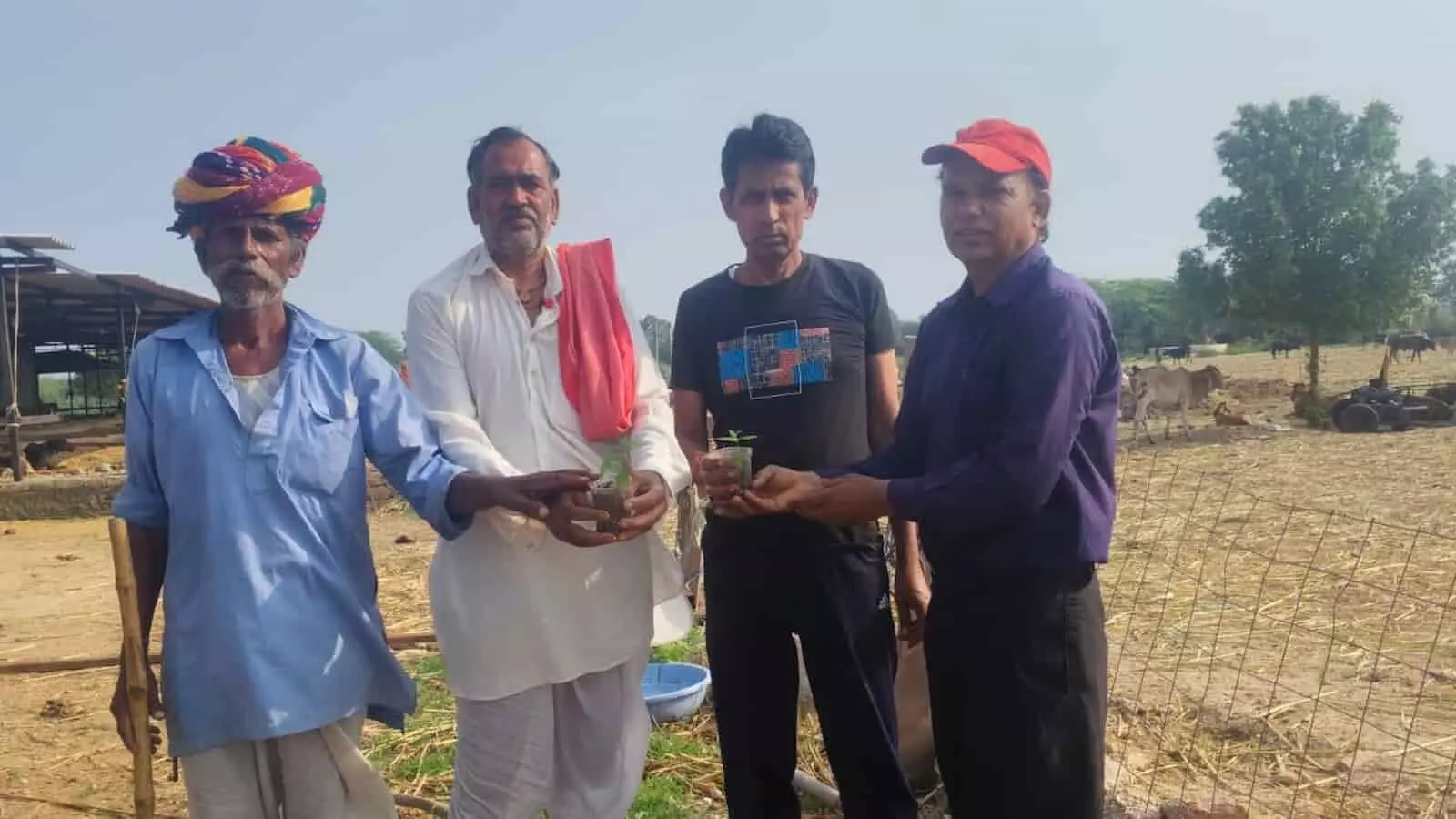 ईन्टाली गौशाला परिसर में हाथों में छोटा पारिजात का पौधा पकड़े खड़े चार लोग।
