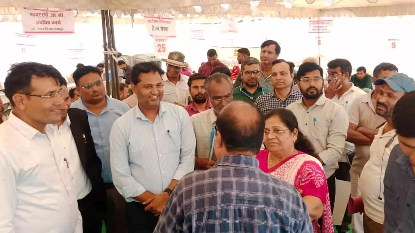 तस्वीर में एक प्रशासनिक शिविर के दौरान टेंट के नीचे आपस में चर्चा करते लोग और सरकारी अधिकारी।