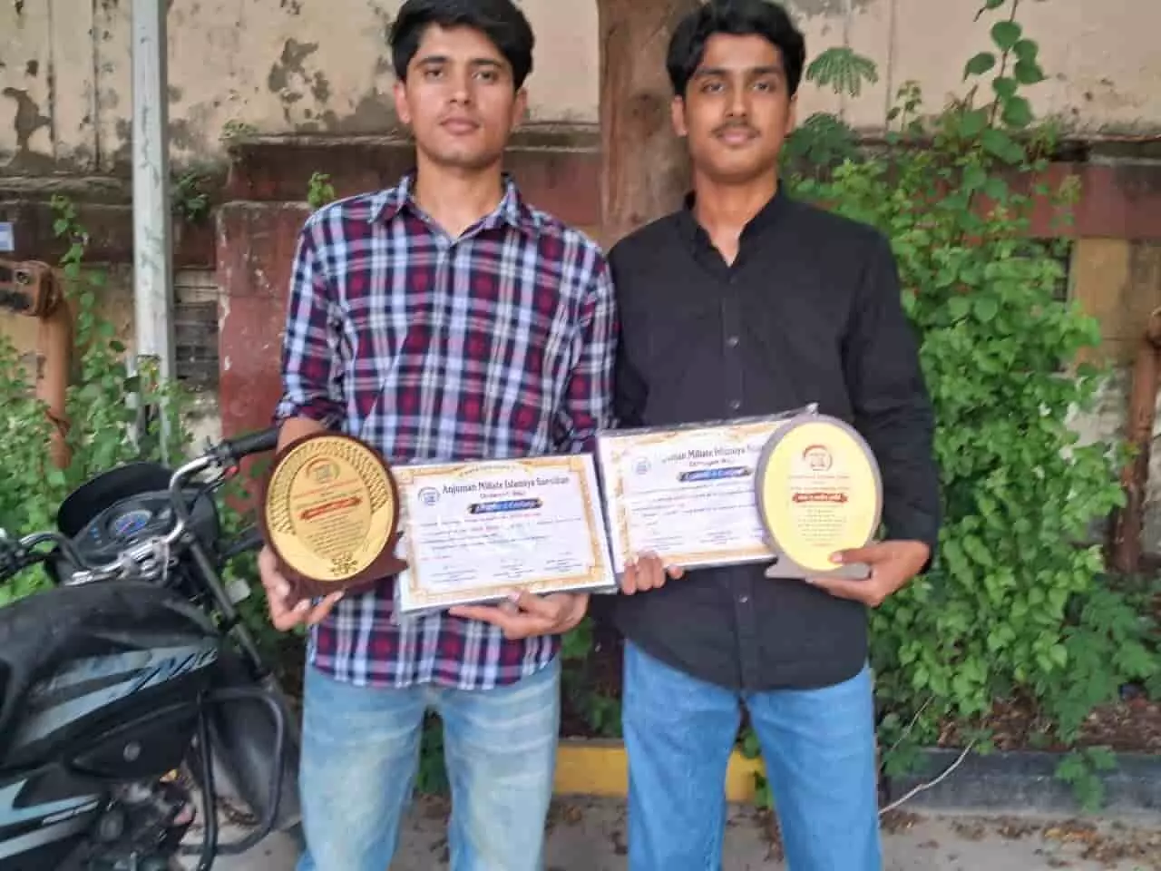 अब्बास हुसैन और रेहान कुरैशी चित्तौड़गढ़ में एक्सीलेंस अवॉर्ड और प्रमाण पत्र पकड़े हुए खड़े हैं।