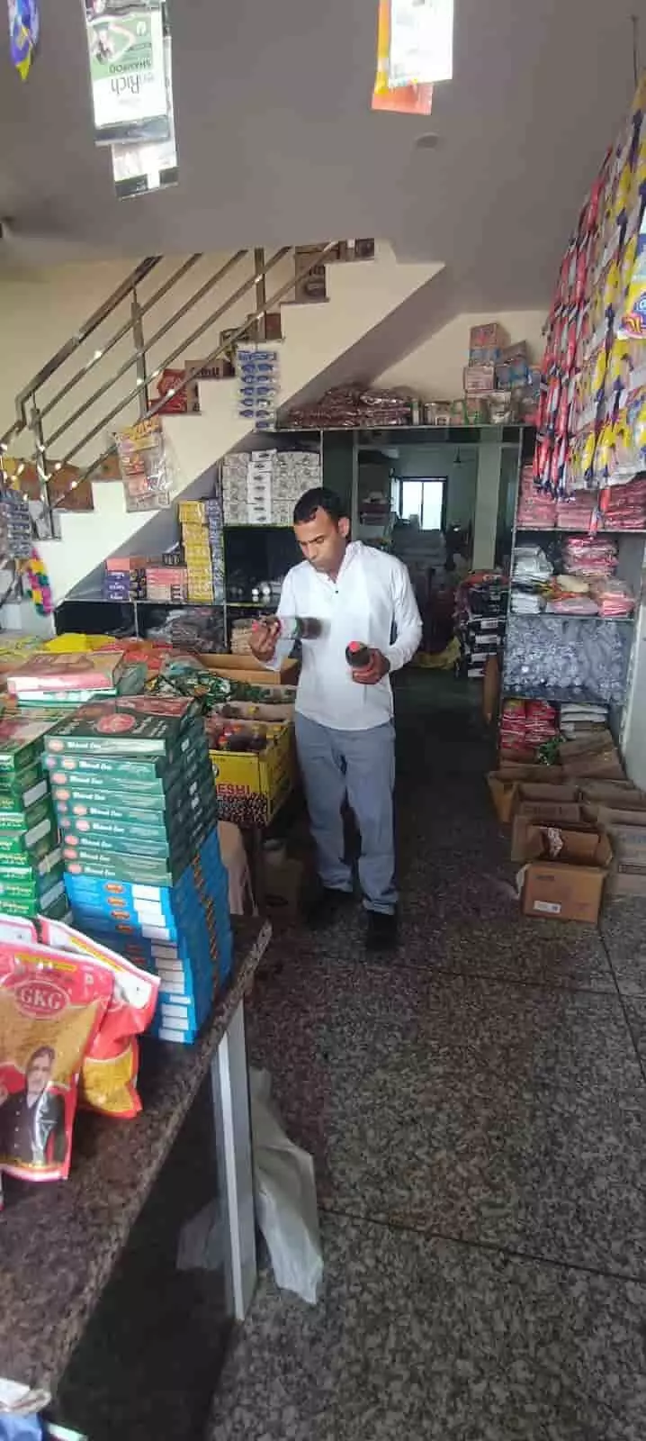 एक अधिकारी आसीन्द की दुकान में खाद्य सामग्री की जांच कर रहे हैं।