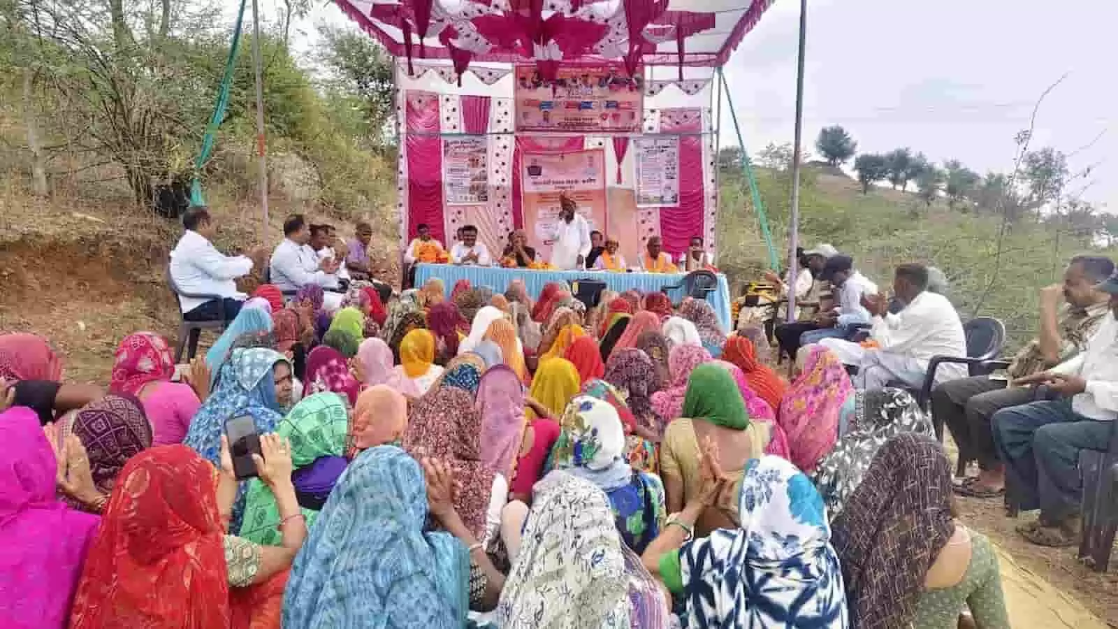 कार्यक्रम में मंच पर संबोधित करते अतिथि और सामने बैठी ग्रामीण महिलाओं की भीड़। कार्यक्रम में मंच पर संबोधित करते अतिथि और सामने बैठी ग्रामीण महिलाओं की भीड़।