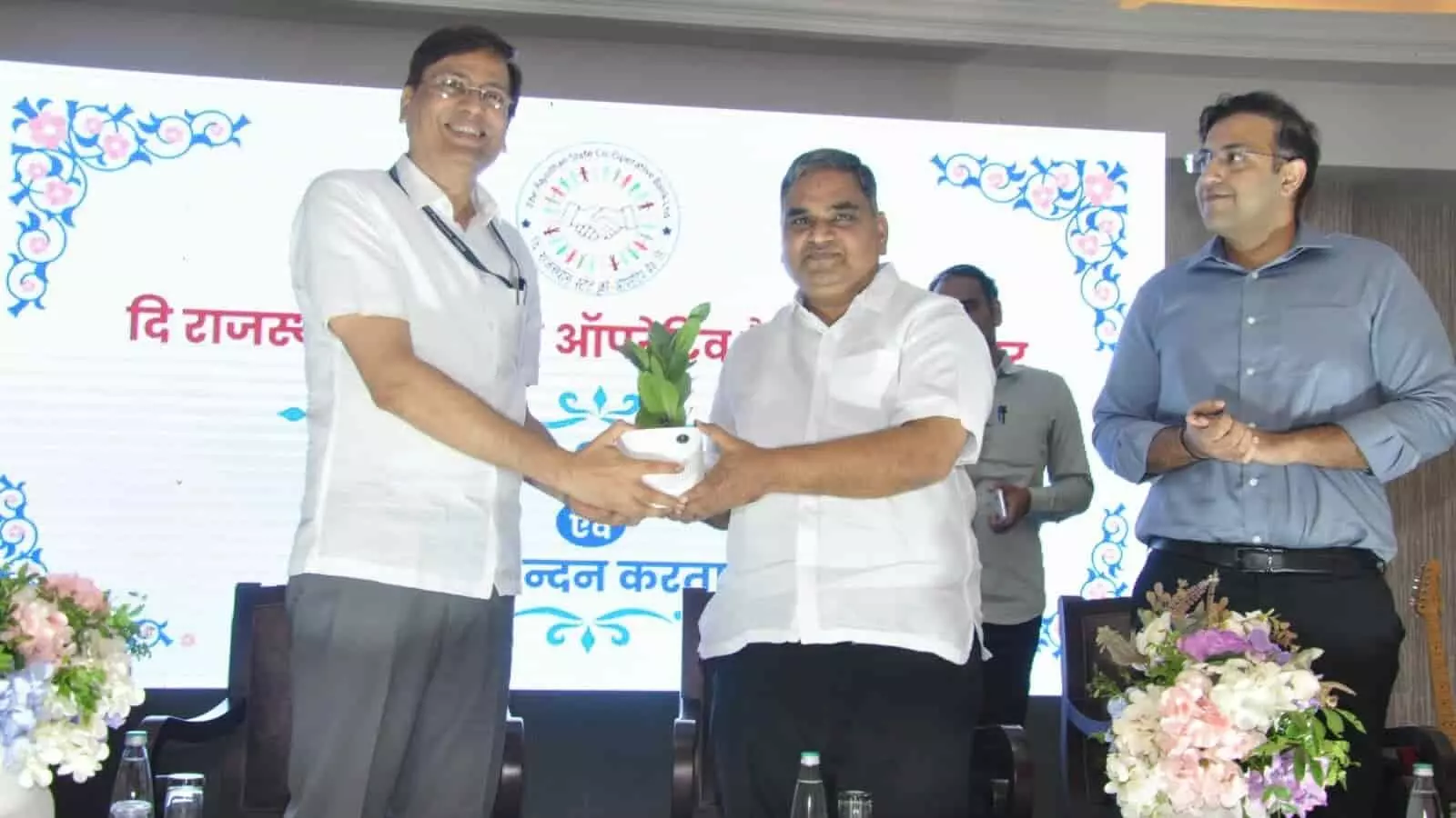 तस्वीर में डॉ. समित शर्मा जयपुर में आयोजित सहकारिता समारोह के दौरान मंत्री गौतम कुमार दक को पौधा भेंट कर रहे हैं।