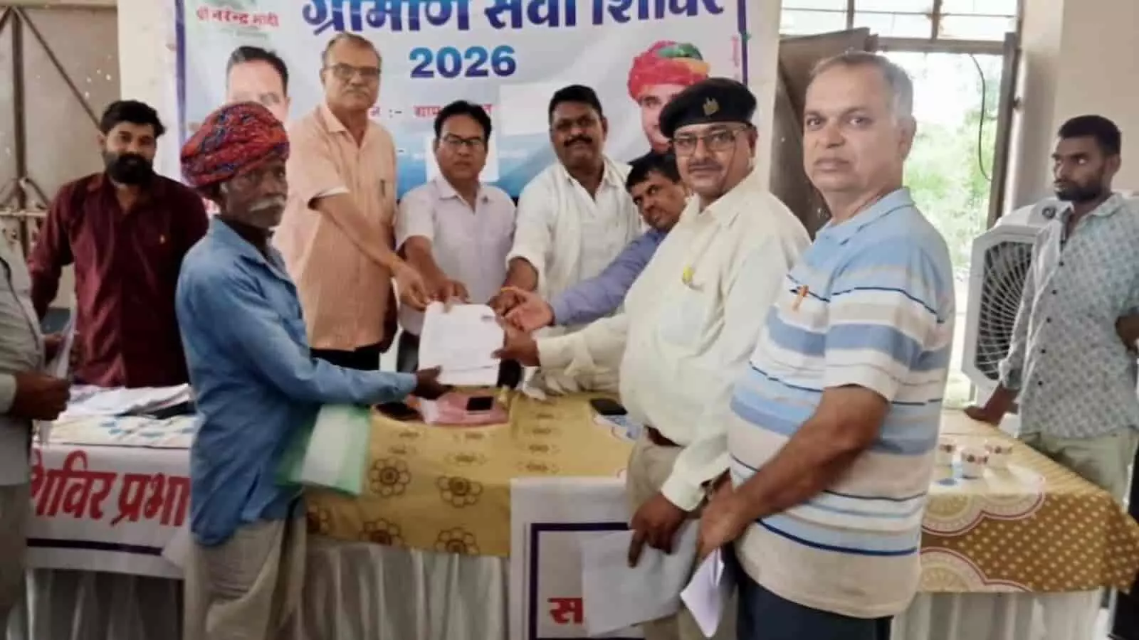 ग्रामीण सेवा शिविर में सरकारी अधिकारियों द्वारा एक व्यक्ति को रोडवेज पास देते हुए तस्वीर। ग्रामीण सेवा शिविर में सरकारी अधिकारियों द्वारा एक व्यक्ति को रोडवेज पास देते हुए तस्वीर।
