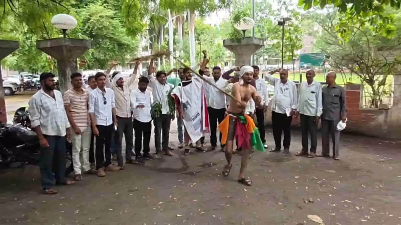 कलेक्ट्रेट के बाहर प्रदर्शन करते किसान और चाबुक लहराता युवक विरोध प्रदर्शन के दौरान। कलेक्ट्रेट के बाहर प्रदर्शन करते किसान और चाबुक लहराता युवक विरोध प्रदर्शन के दौरान।