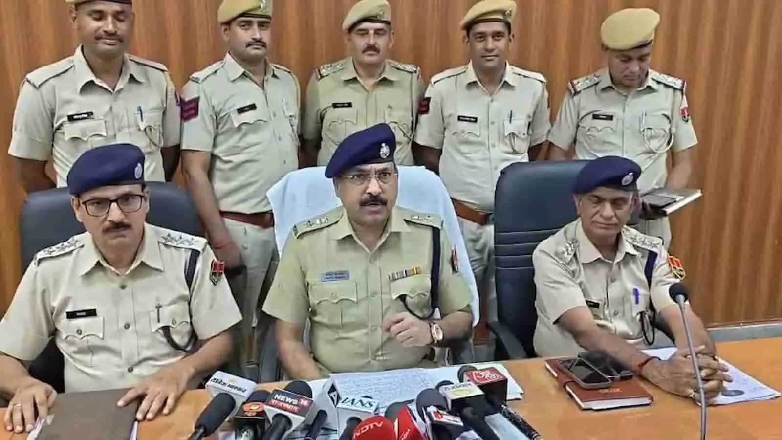तस्वीर में दिख रही पुलिस टीम प्रेस वार्ता कक्ष में माइक के सामने बैठकर जानकारी दे रही है।