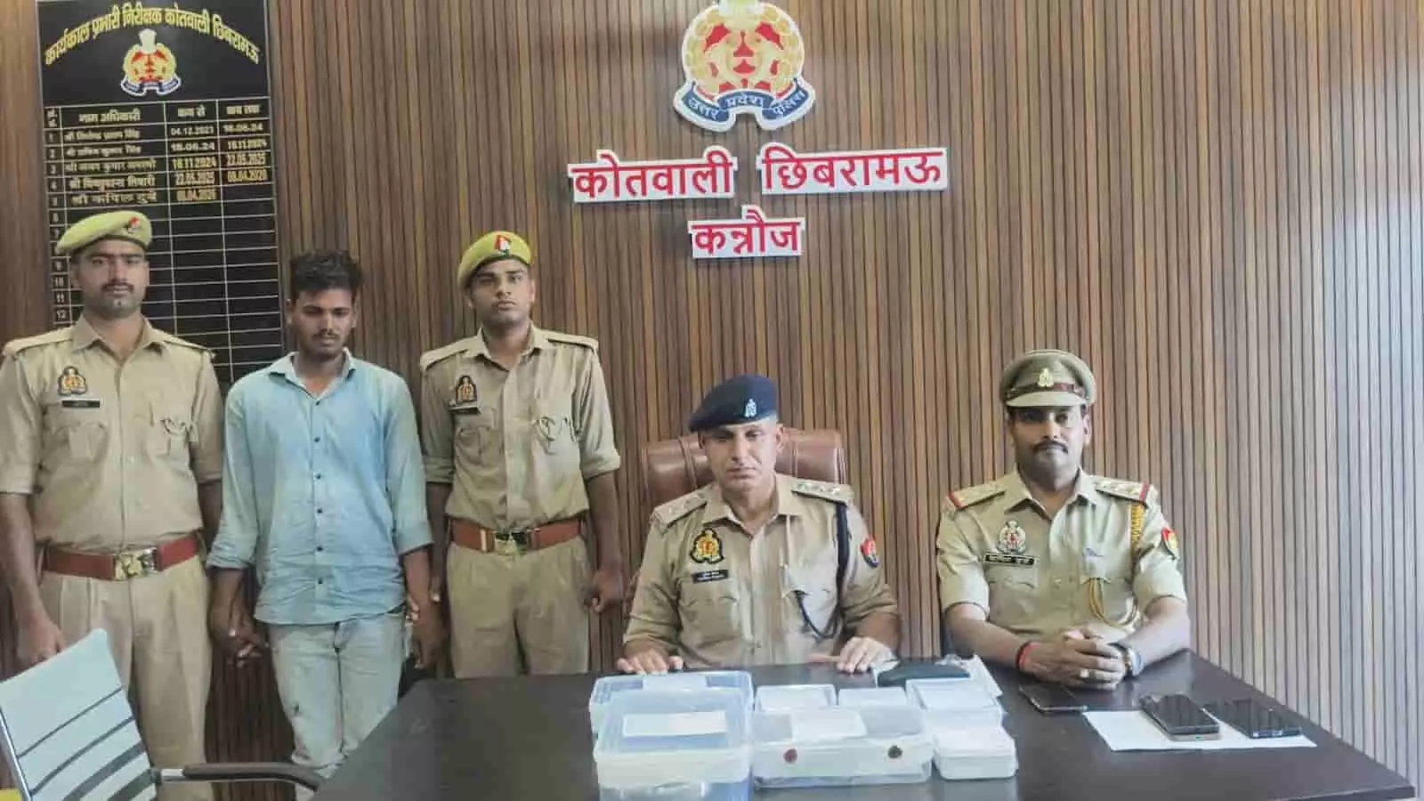 छिबरामऊ कोतवाली में पुलिसकर्मियों की हिरासत में खड़ा लूट का आरोपी और बैठे अधिकारी।
