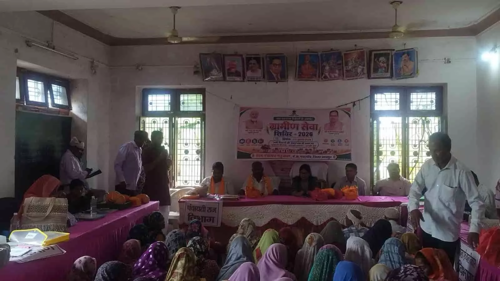 ग्राम सेवा शिविर बैठक में मंच पर उपस्थित अधिकारी और सामने बैठी ग्रामीण महिलाएं। ग्राम सेवा शिविर बैठक में मंच पर उपस्थित अधिकारी और सामने बैठी ग्रामीण महिलाएं।