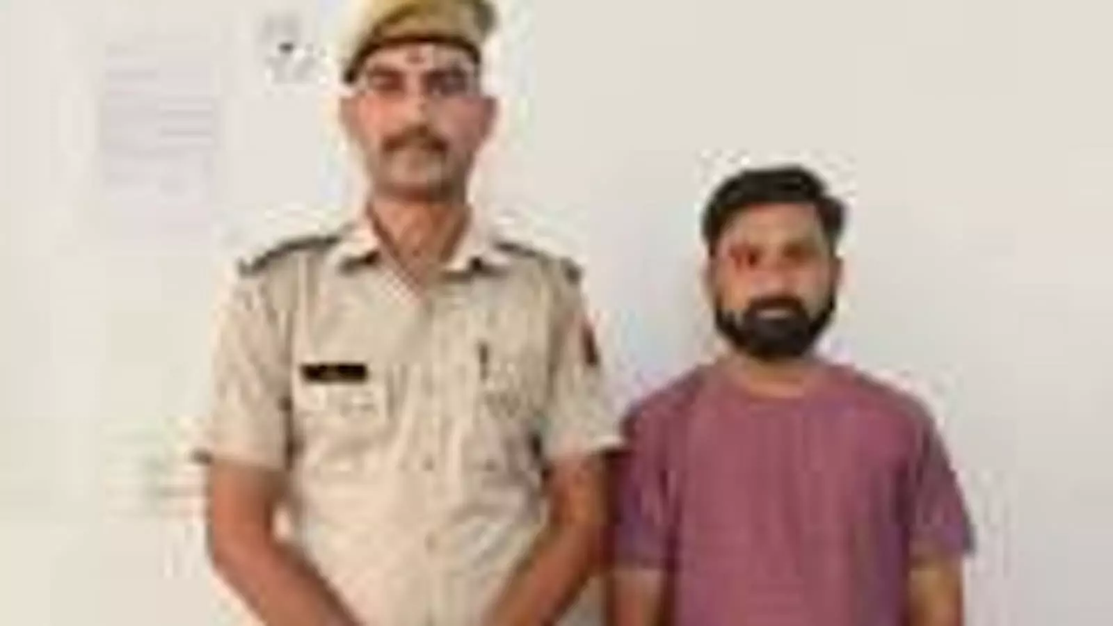 तस्वीर में साइबर क्राइम थाना के पुलिस कांस्टेबल और एक व्यक्ति सीधे खड़े दिखाई दे रहे हैं।