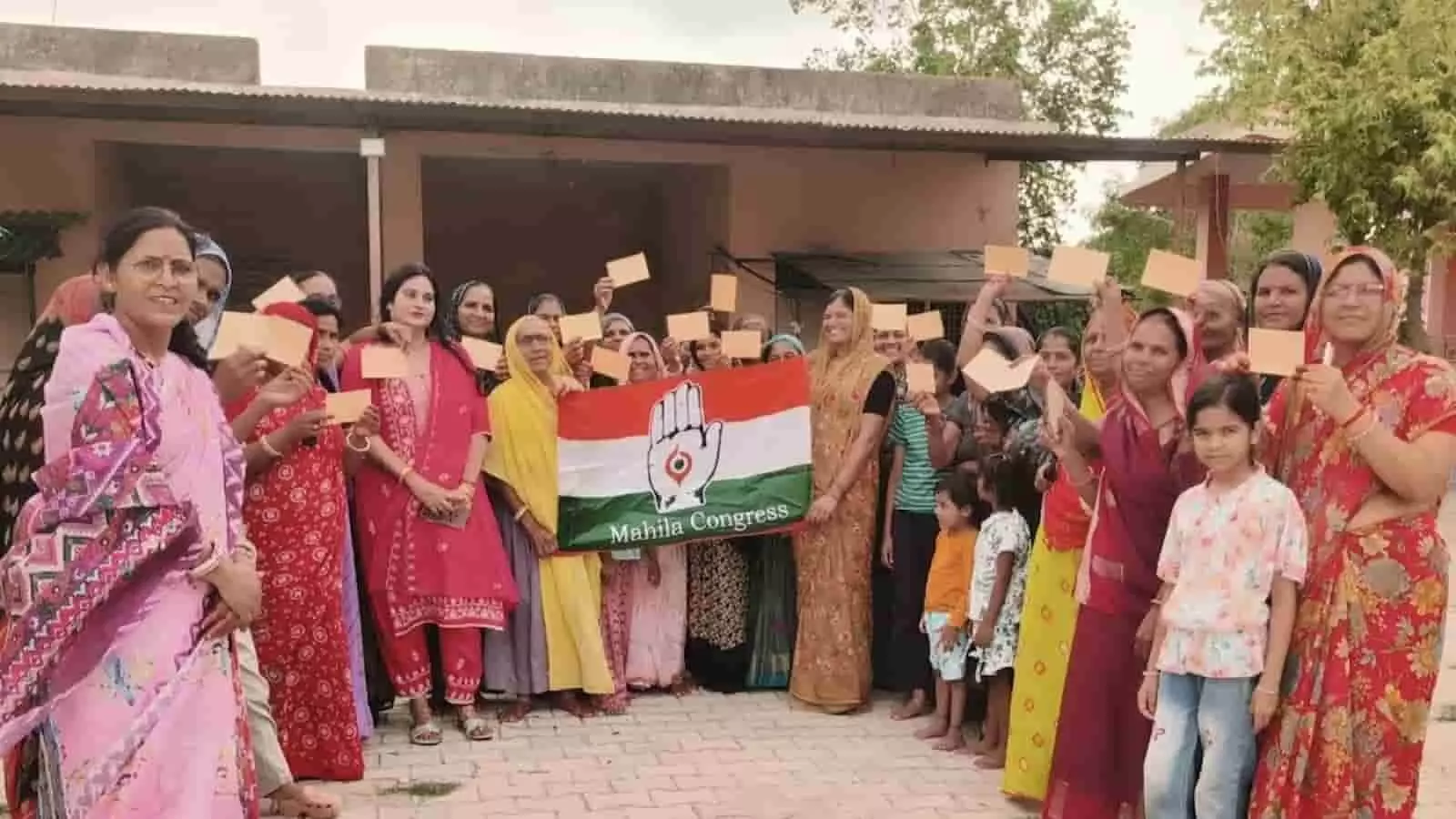 महिलाएं बारां में हाथ में पोस्टकार्ड और महिला कांग्रेस का झंडा लिए खड़ी हैं।