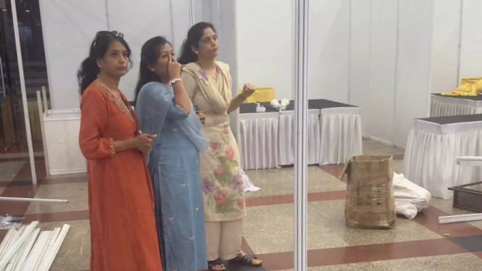 तीन महिलाएं कोटा में आयोजित उड़ान ट्रेड फेयर में स्टॉल व्यवस्था का निरीक्षण कर रही हैं।