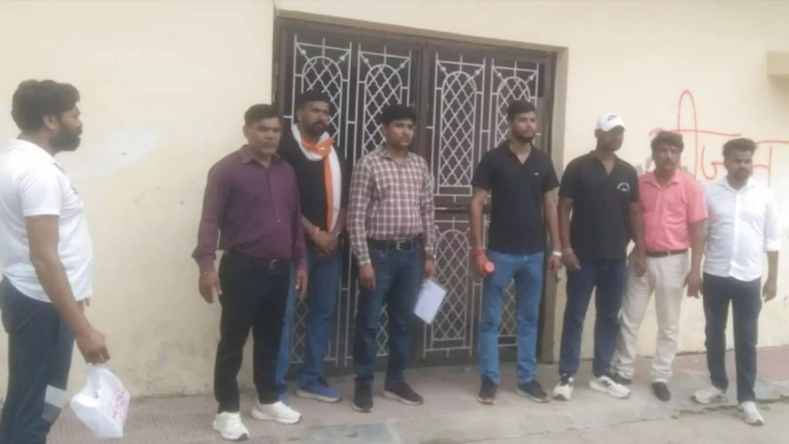 बारां में एक सील किए गए प्रतिष्ठान के बाहर अधिकारी और अन्य लोग खड़े हैं। बारां में एक सील किए गए प्रतिष्ठान के बाहर अधिकारी और अन्य लोग खड़े हैं।