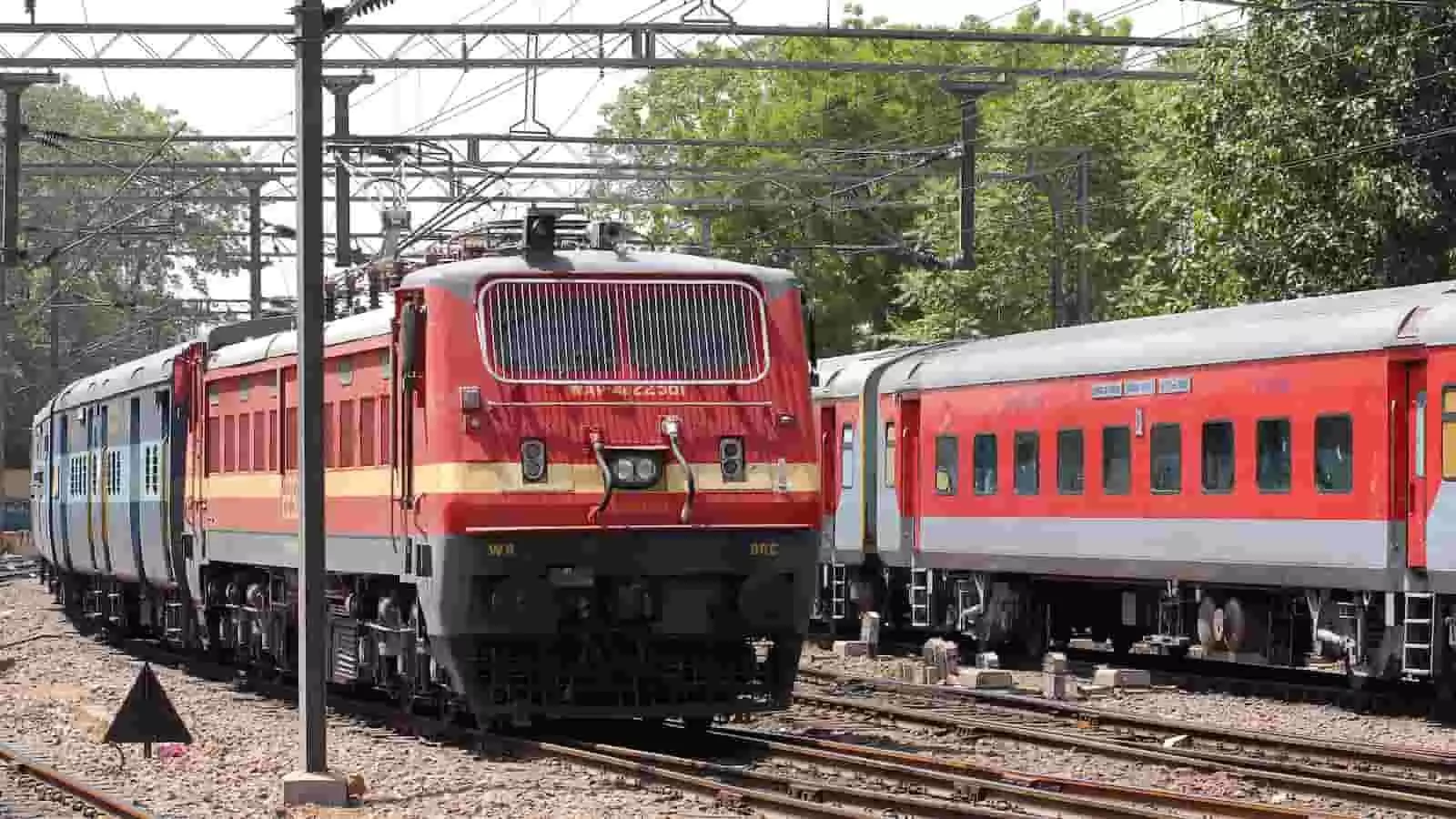 रेलवे ट्रैक पर खड़ी एक इलेक्ट्रिक ट्रेन और यात्री बोगियां दिखाई दे रही हैं। रेलवे ट्रैक पर खड़ी एक इलेक्ट्रिक ट्रेन और यात्री बोगियां दिखाई दे रही हैं।