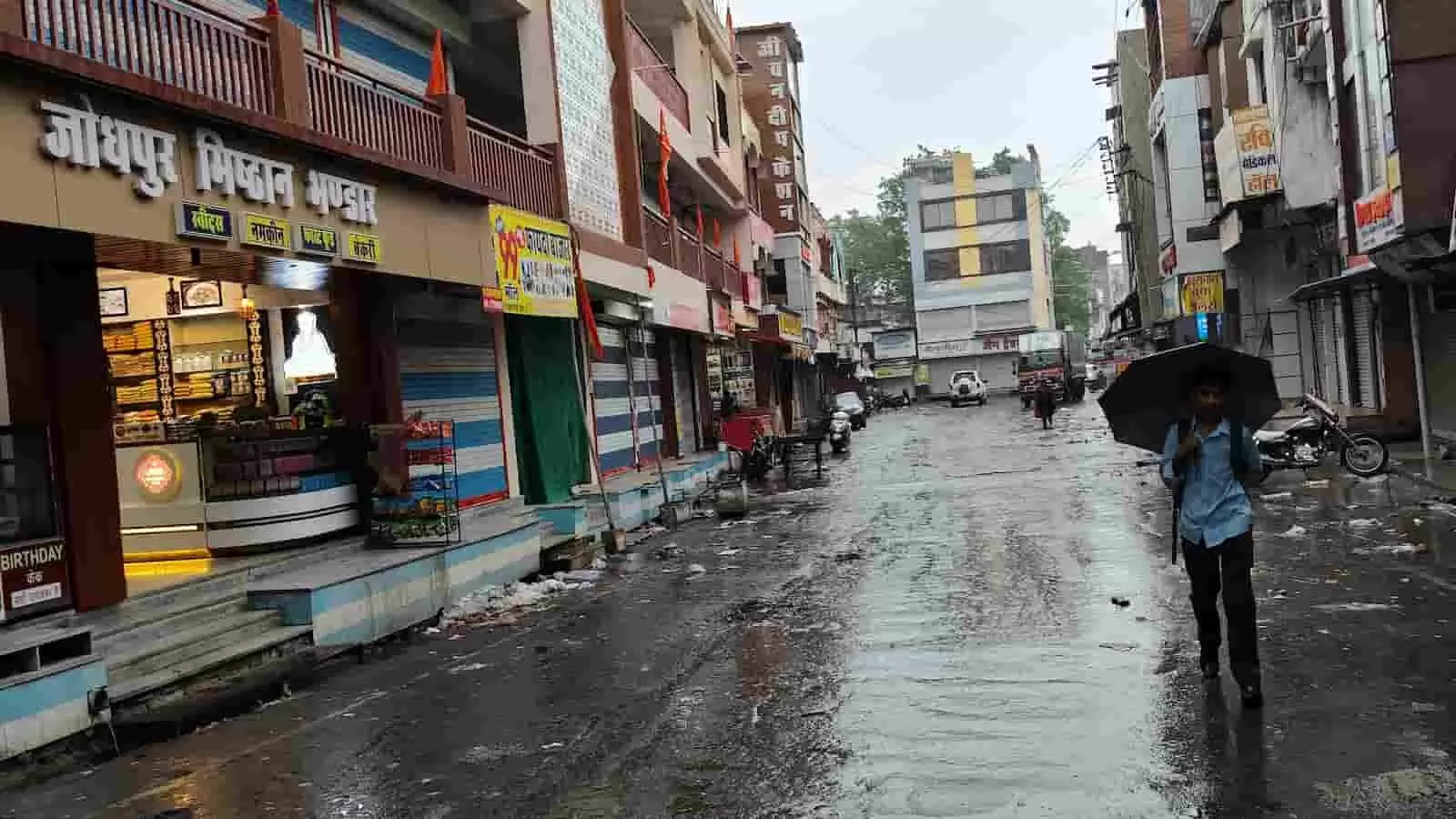 खेरवाड़ा कस्बे में बारिश के बाद सड़क पर छाता लेकर चलता युवक। खेरवाड़ा कस्बे में बारिश के बाद सड़क पर छाता लेकर चलता युवक।