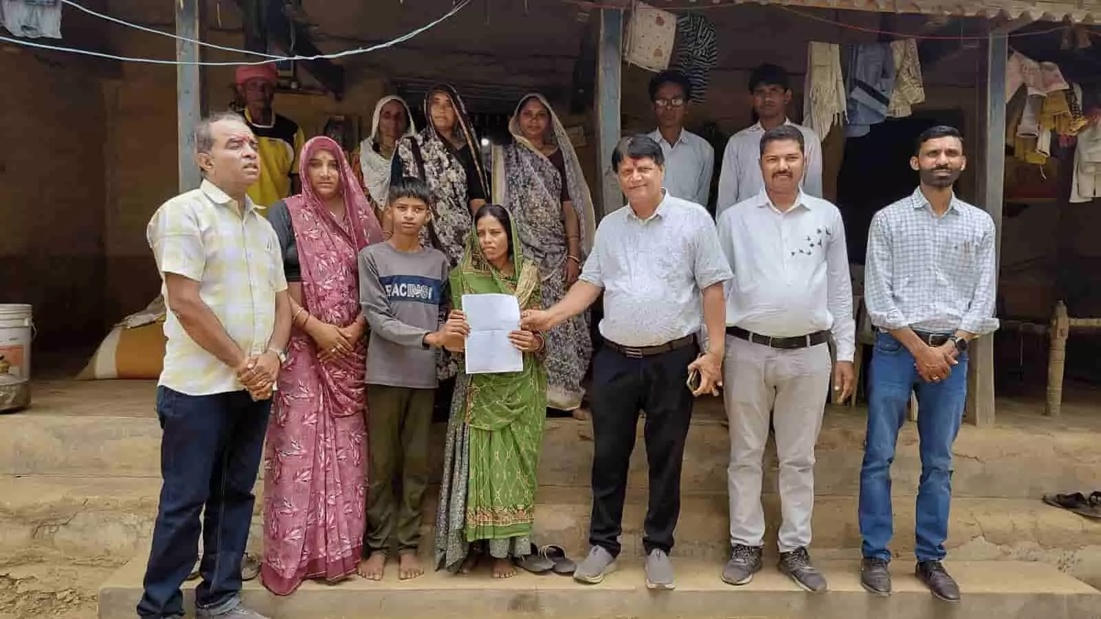 एलआईसी अधिकारी और जनप्रतिनिधि खेरवाड़ा में महिला को बीमा दस्तावेज सौंप रहे हैं।