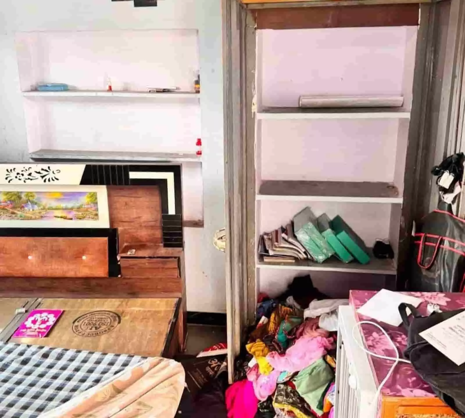 कमरे में खुली अलमारी और फर्श पर बिखरे हुए कपड़ों का दृश्य। कमरे में खुली अलमारी और फर्श पर बिखरे हुए कपड़ों का दृश्य।