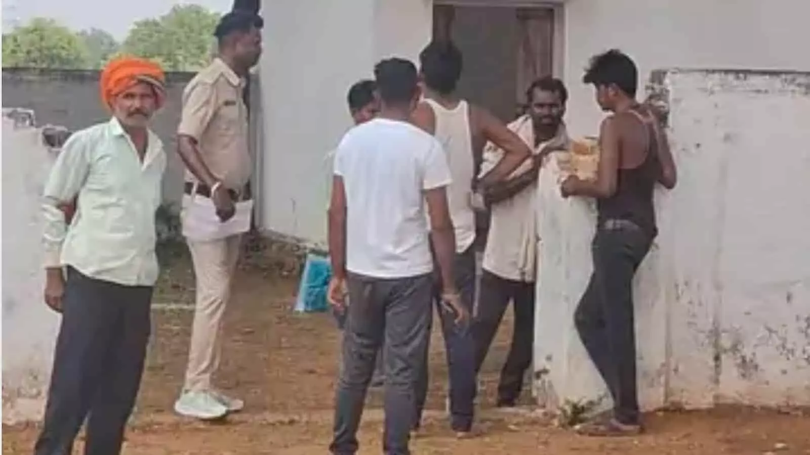 बड़वारा में एक इमारत के बाहर पुलिसकर्मी और स्थानीय ग्रामीणों की खड़ी भीड़ जांच करती हुई। बड़वारा में एक इमारत के बाहर पुलिसकर्मी और स्थानीय ग्रामीणों की खड़ी भीड़ जांच करती हुई।