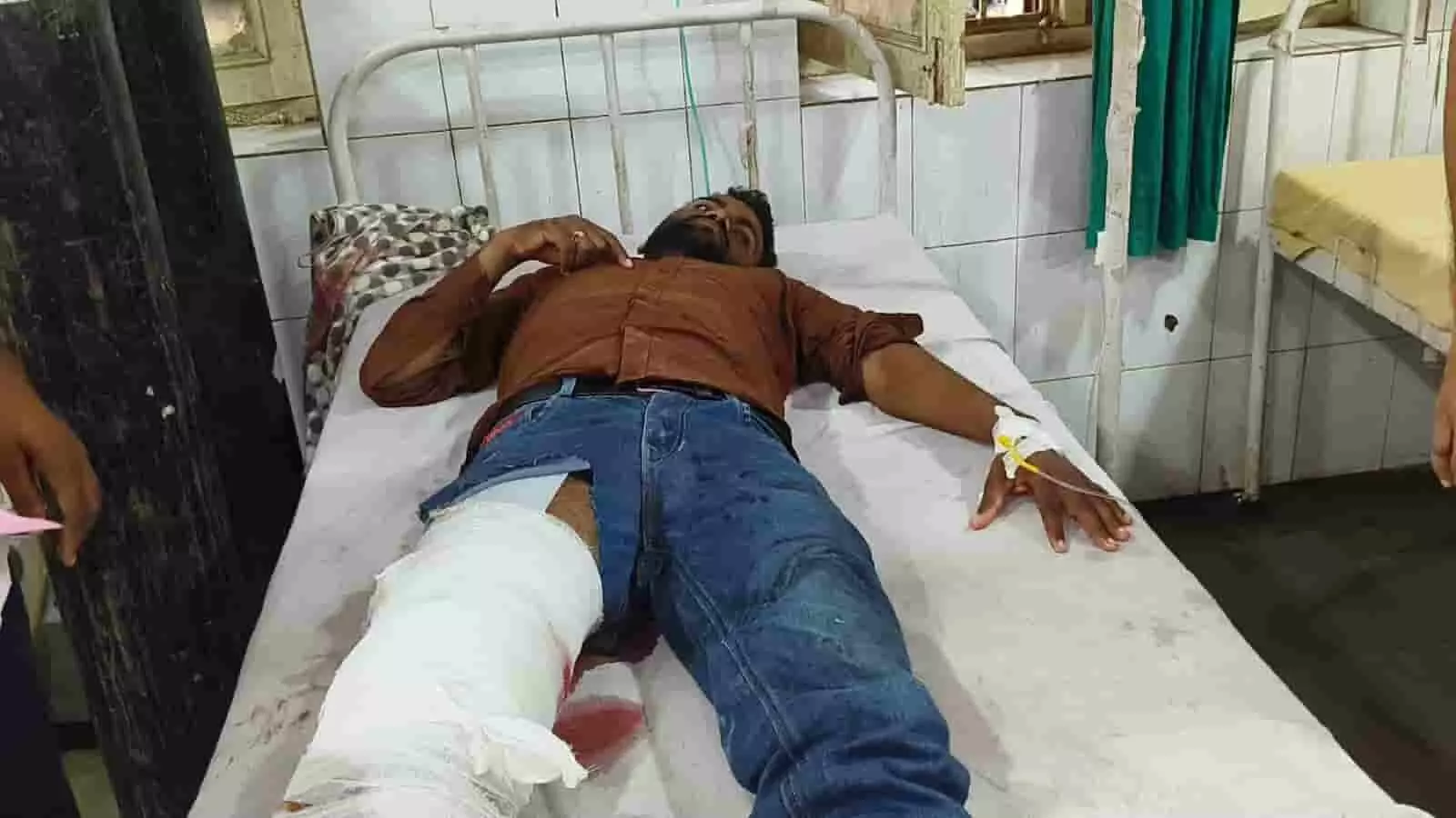 अस्पताल के बेड पर लेटा उपचाराधीन घायल व्यक्ति जिसके पैर पर पट्टी बंधी है। अस्पताल के बेड पर लेटा उपचाराधीन घायल व्यक्ति जिसके पैर पर पट्टी बंधी है।