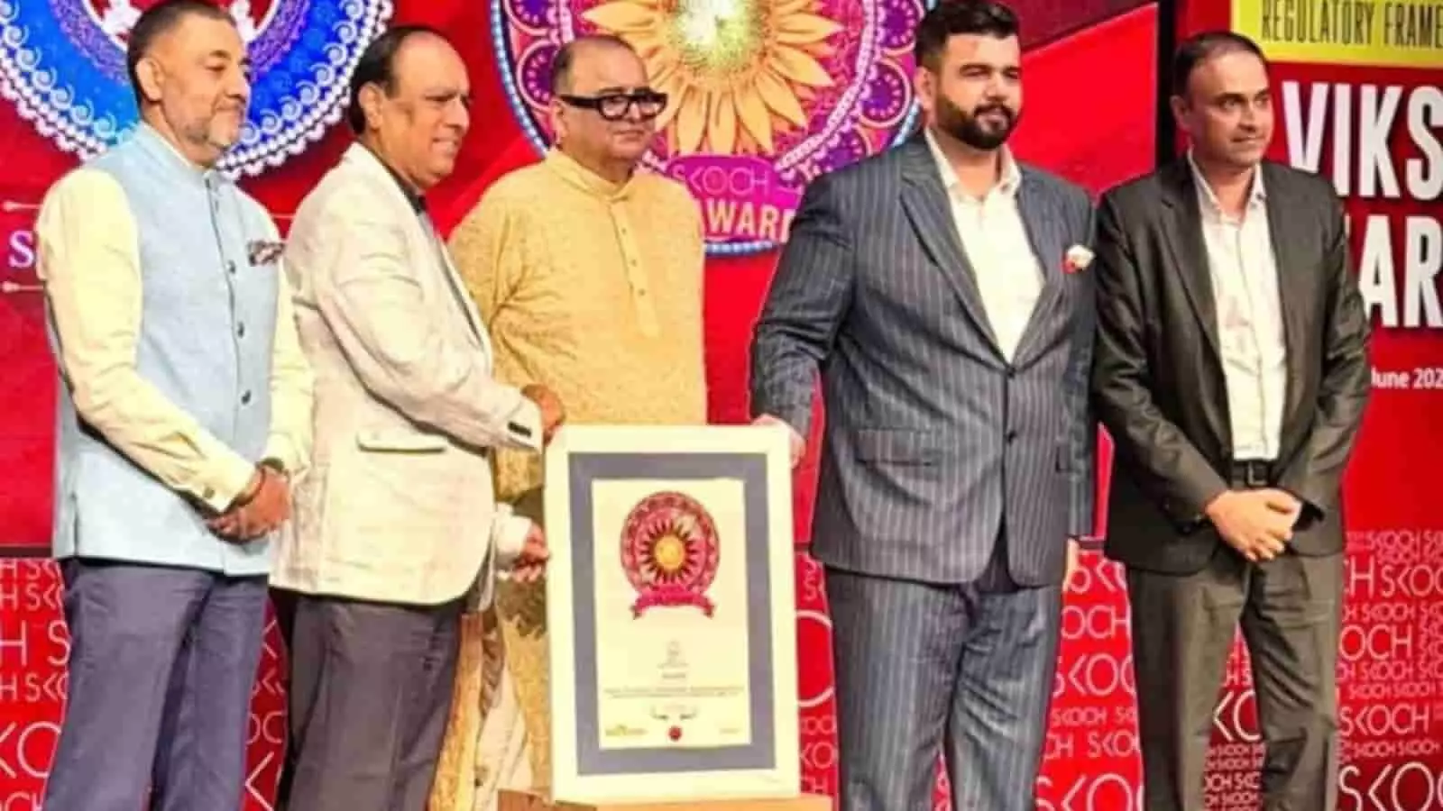 स्कॉच पुरस्कार समारोह के मंच पर फ्रेम किया हुआ प्रमाणपत्र थामे हुए MKCL के अधिकारी।