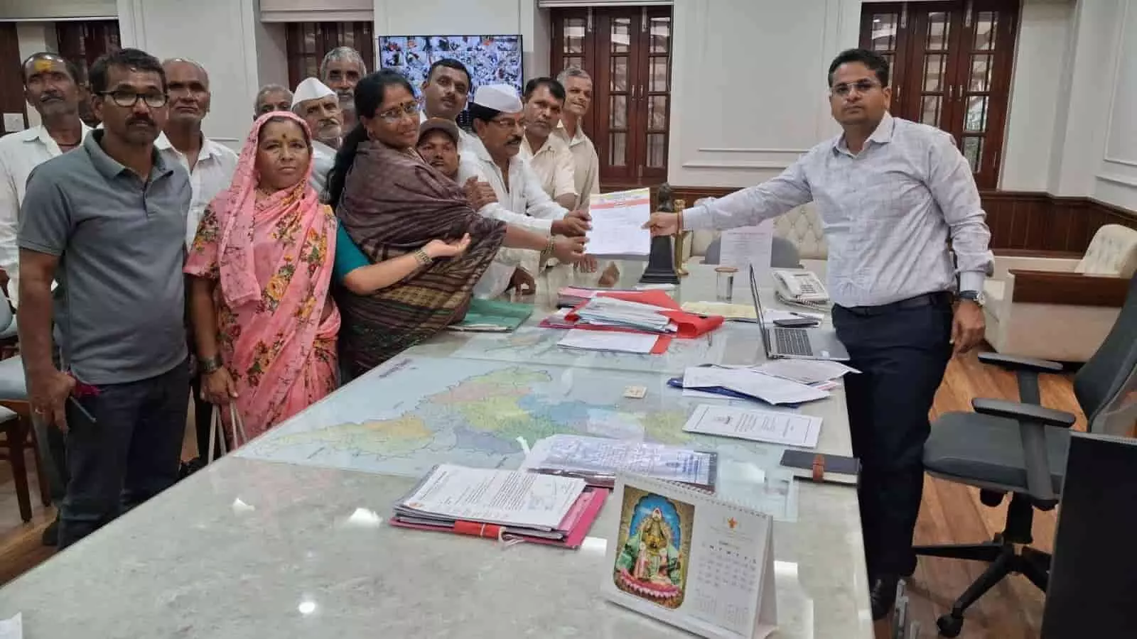 तस्वीर में ग्रामीण प्रतिनिधिमंडल जिलाधिकारी डॉ. विजय राठोड को कार्यालय में ज्ञापन सौंपते हुए दिख रहा है।