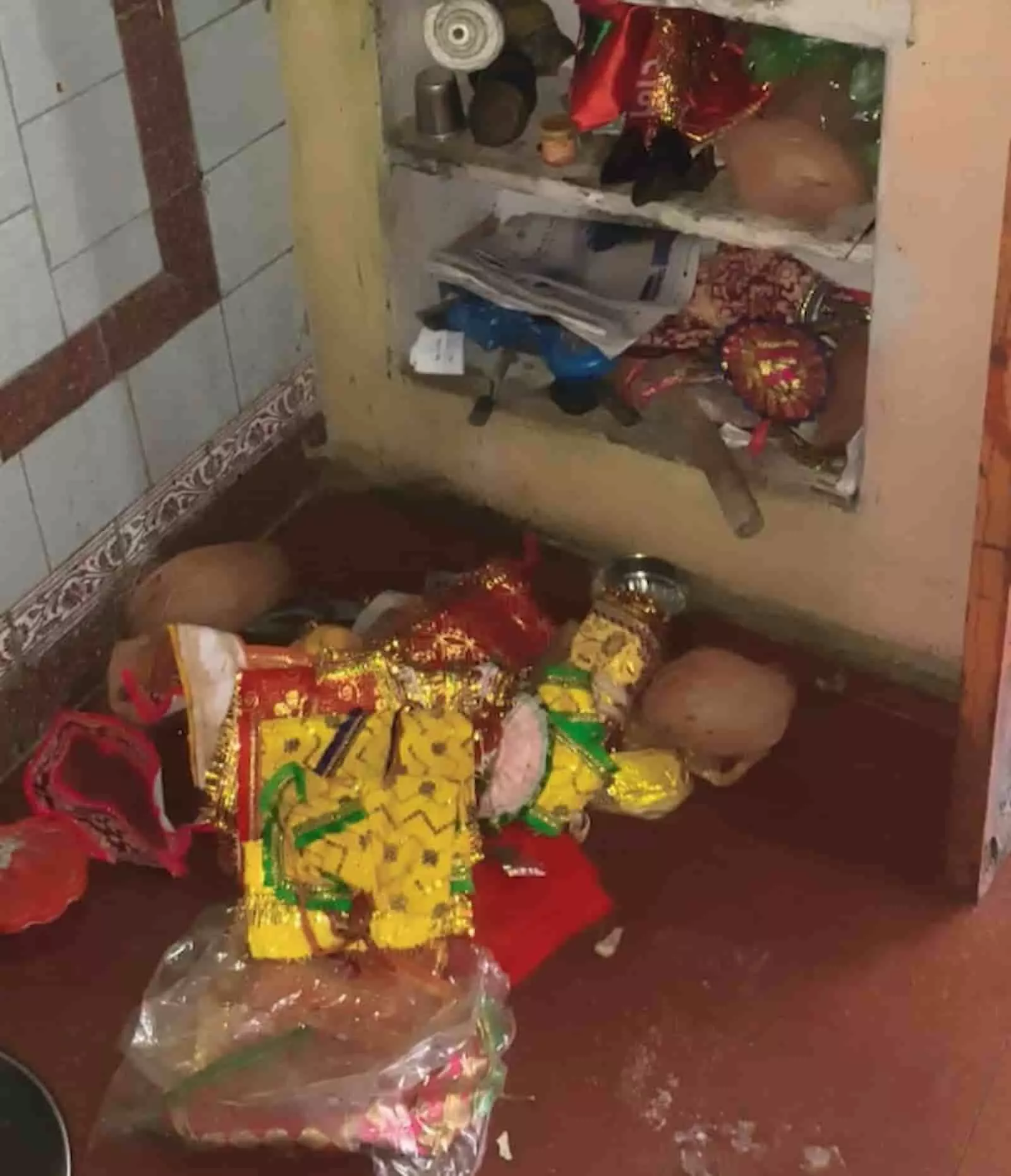 मंदिर के फर्श पर बिखरा हुआ पूजा और धार्मिक उत्सव का सामान दिख रहा है। मंदिर के फर्श पर बिखरा हुआ पूजा और धार्मिक उत्सव का सामान दिख रहा है।