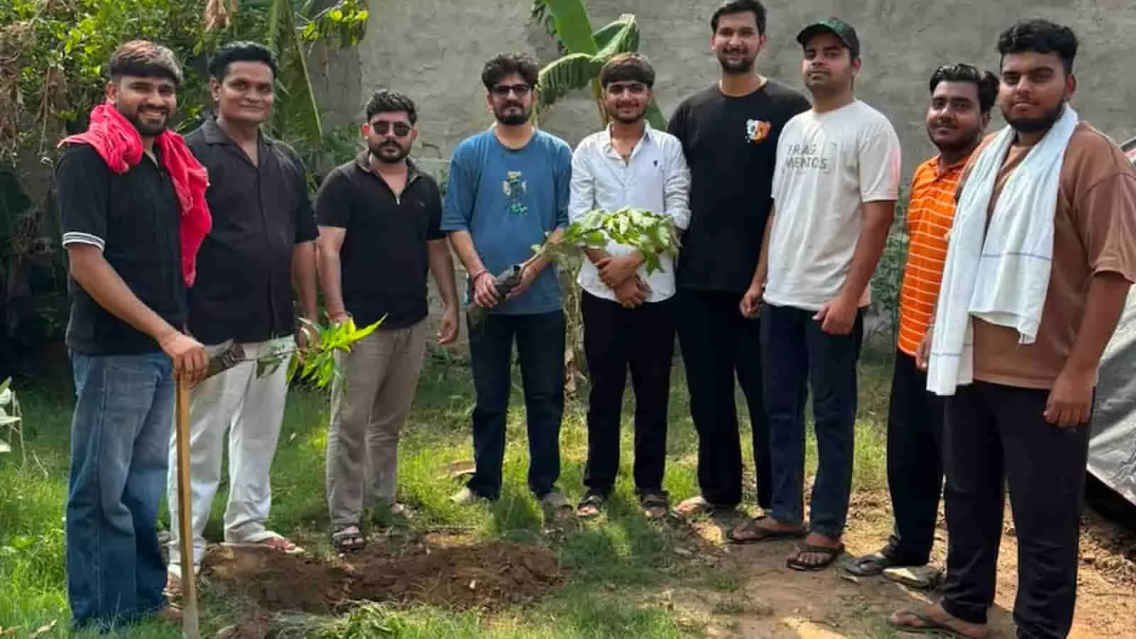 तस्वीर में युवा सदस्य पौधों के साथ खुले परिसर में वृक्षारोपण के संदर्भ में खड़े हैं। तस्वीर में युवा सदस्य पौधों के साथ खुले परिसर में वृक्षारोपण के संदर्भ में खड़े हैं।