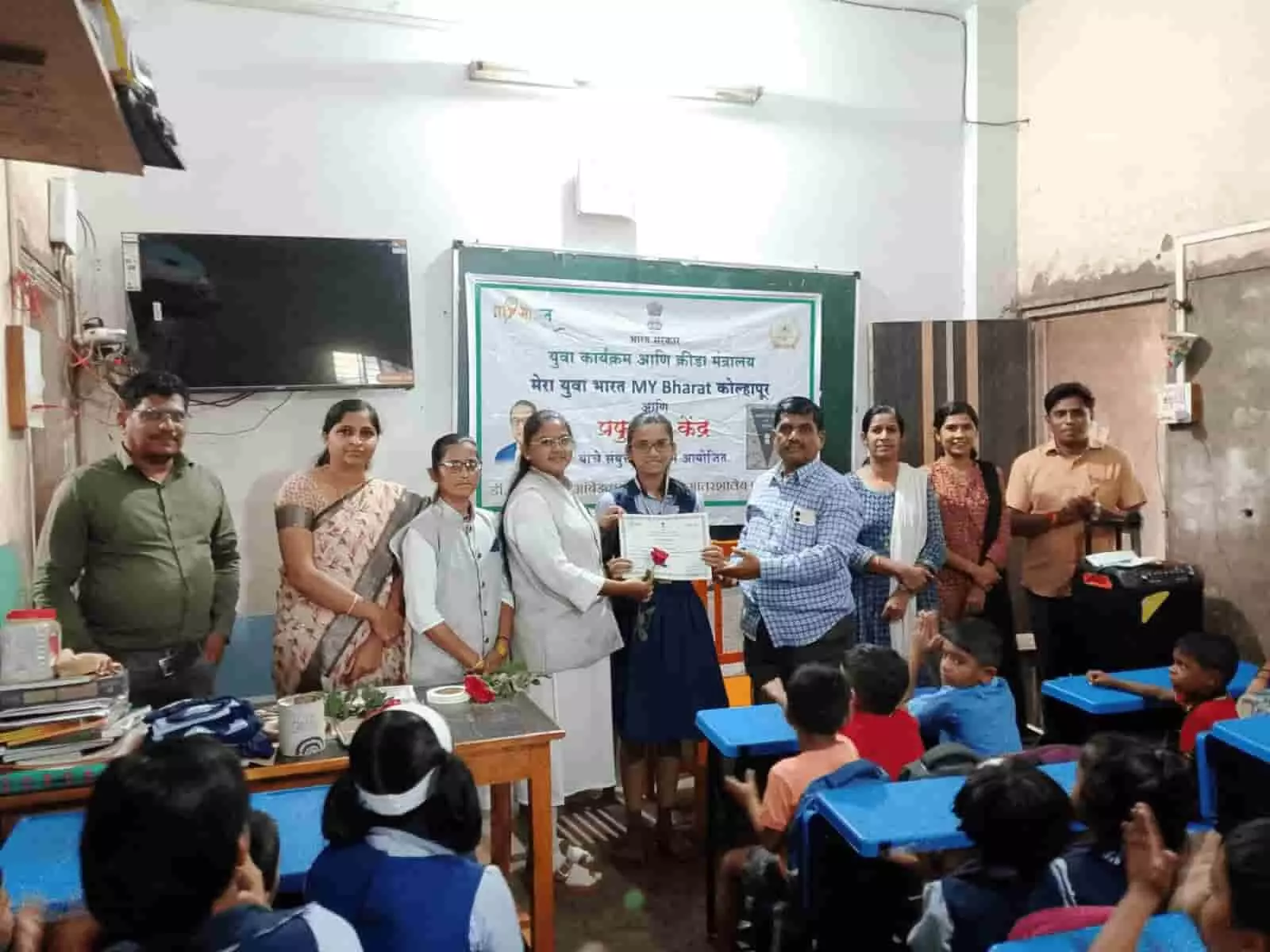 तस्वीर में छात्रा को प्रमाणपत्र देते शिक्षक और अन्य लोग कक्षा में सम्मान समारोह के दौरान दिखाई दे रहे हैं। तस्वीर में छात्रा को प्रमाणपत्र देते शिक्षक और अन्य लोग कक्षा में सम्मान समारोह के दौरान दिखाई दे रहे हैं।