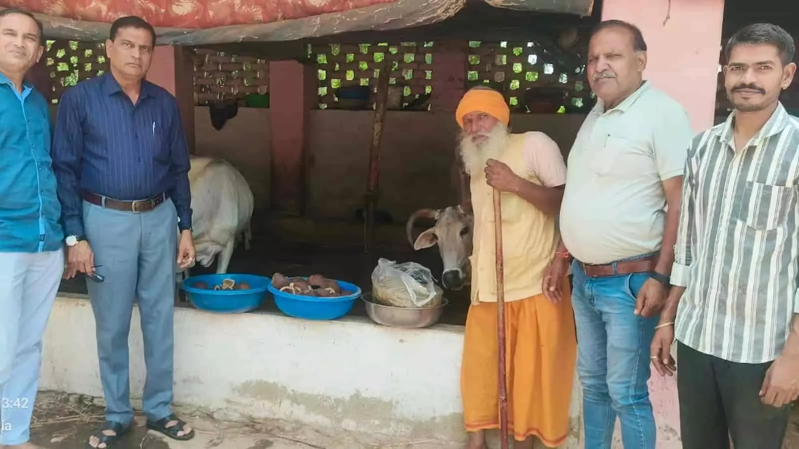 गौशाला में गाय और सेवा सामग्री के पास खड़े महावीर इंटरनेशनल के सदस्य और महंत।
