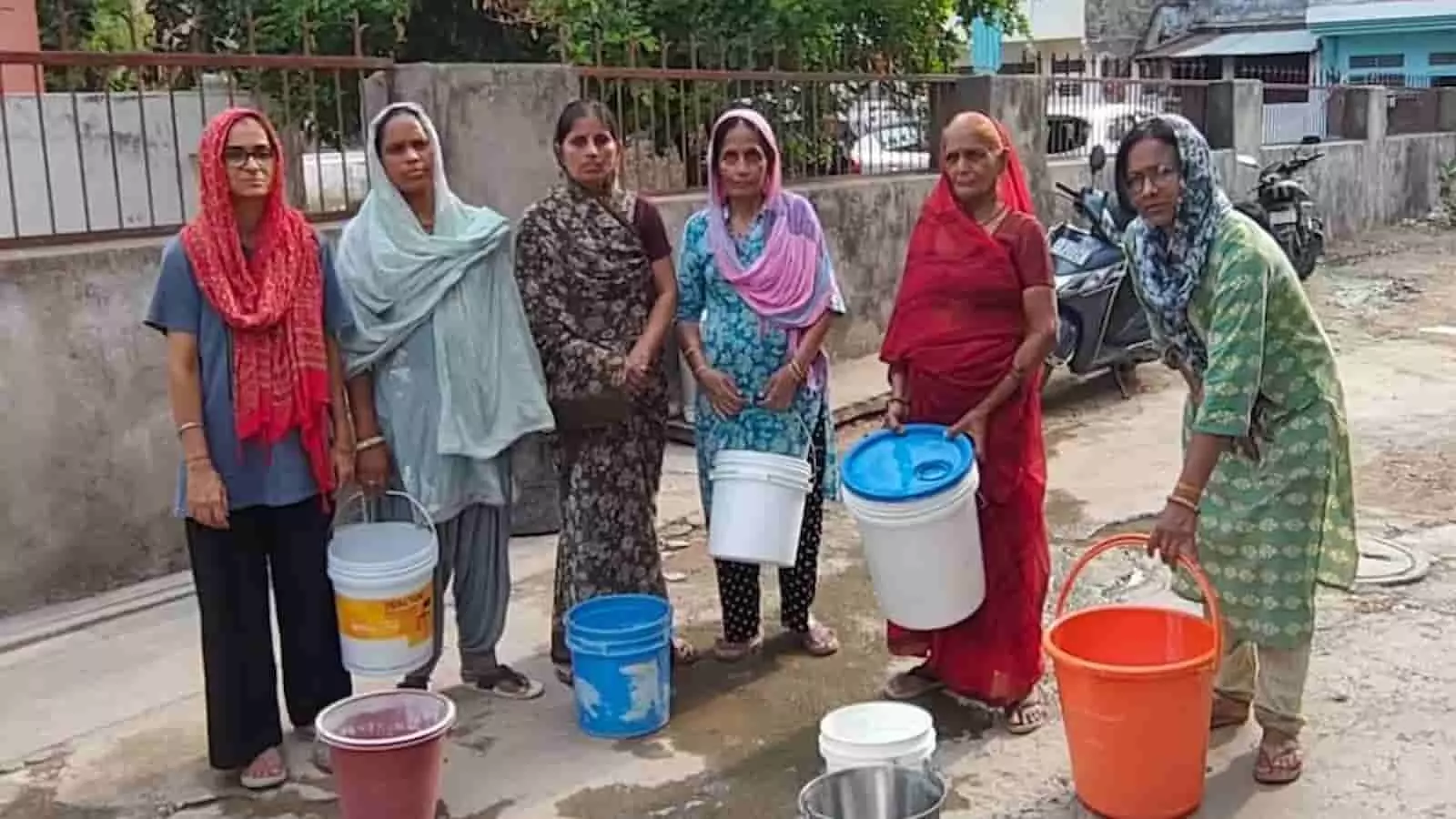 सवाई माधोपुर में महिलाएं हाथ में पानी की बाल्टियां लेकर सड़क पर खड़ी हैं।