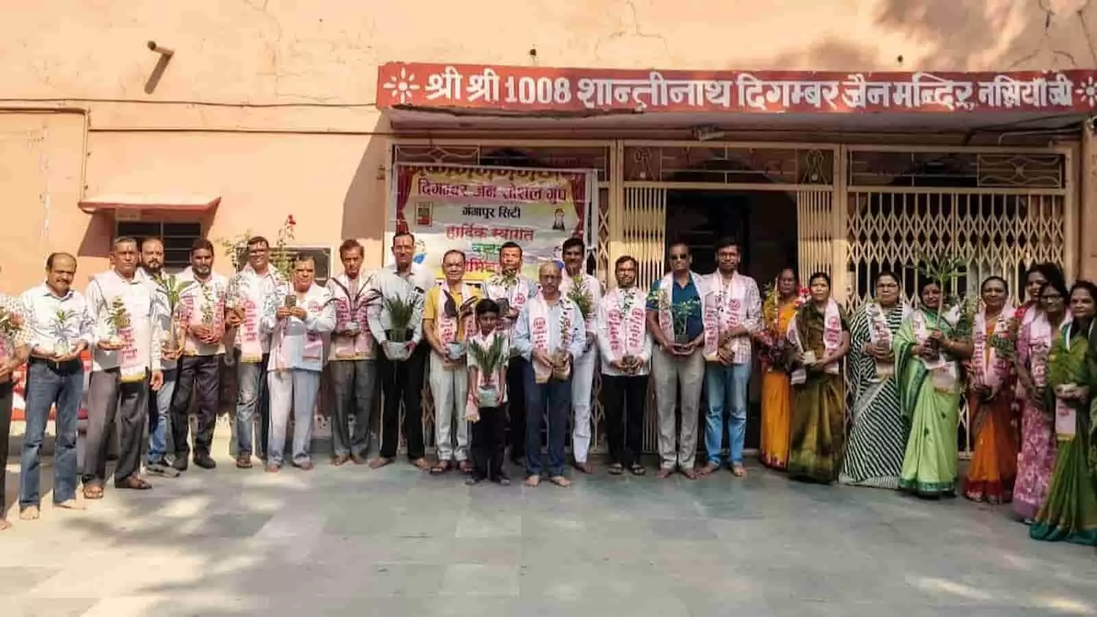 मंदिर परिसर में हाथ में पौधे लिए खड़े दिगंबर जैन सोशल ग्रुप के सदस्य।