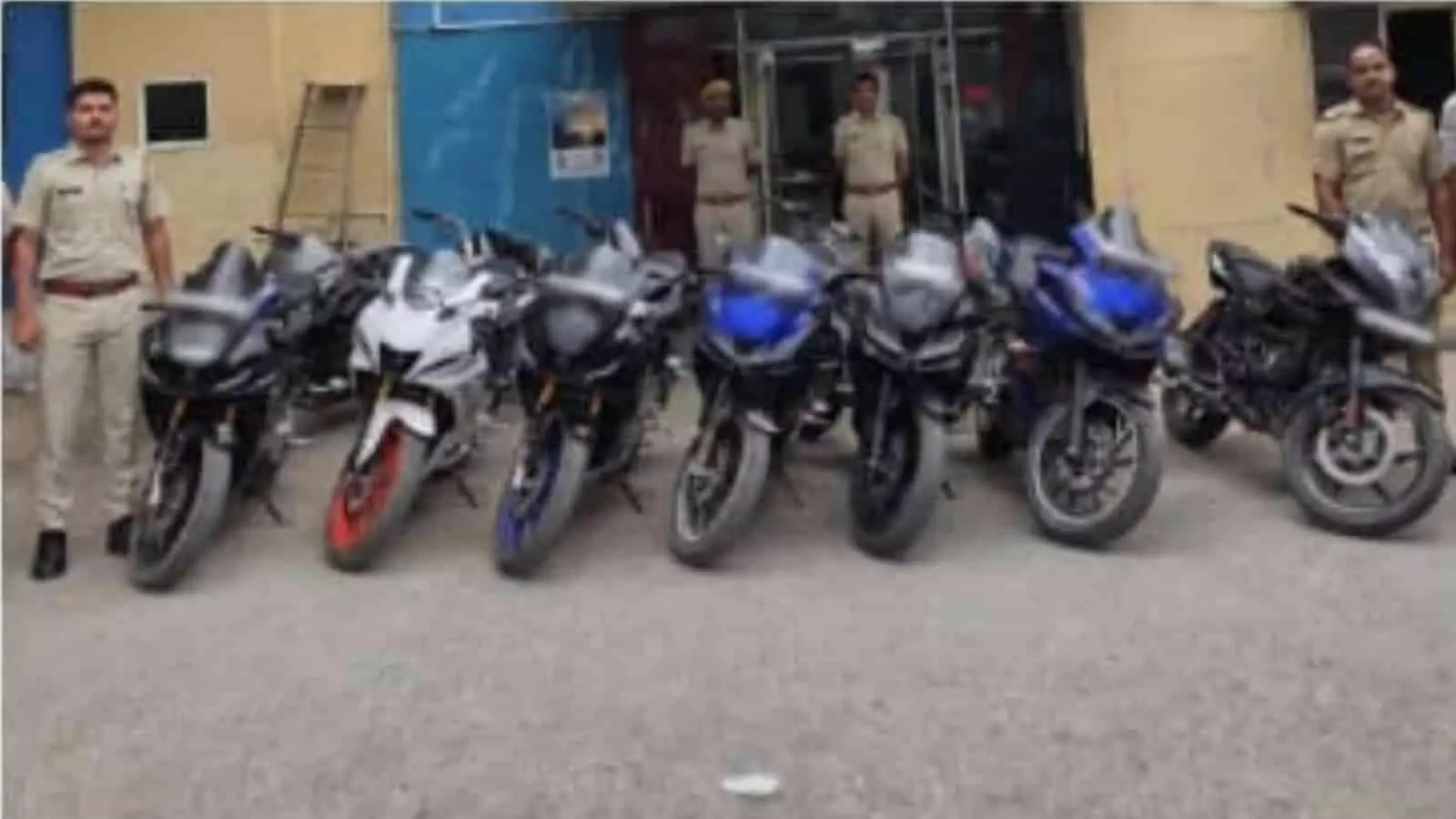 तस्वीर में खेरवाड़ा थाने के बाहर पुलिसकर्मी और जब्त की गई मोटरसाइकिलें खड़ी दिख रही हैं।