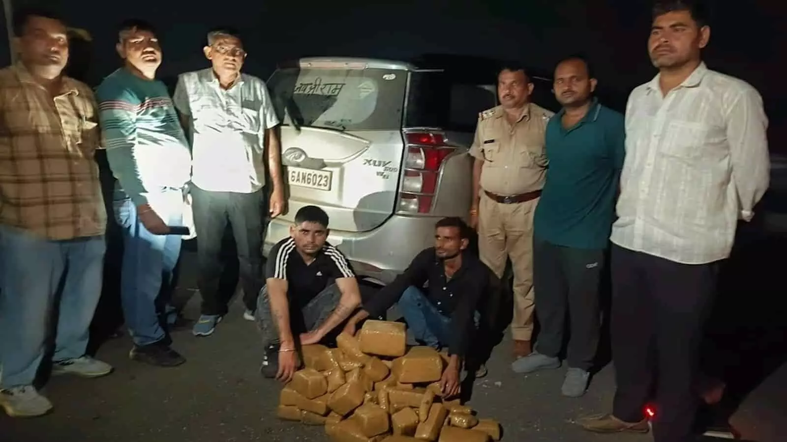 एक्सप्रेसवे पर रात में खड़ी गाड़ी के सामने पुलिसकर्मियों और आरोपियों के पास रखे जब्त गांजे के पैकेट। एक्सप्रेसवे पर रात में खड़ी गाड़ी के सामने पुलिसकर्मियों और आरोपियों के पास रखे जब्त गांजे के पैकेट।