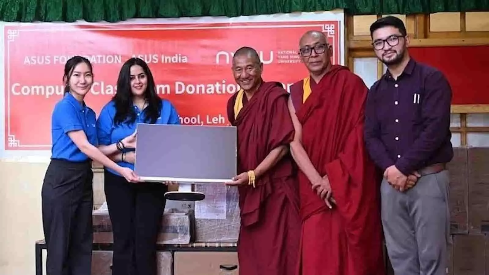 स्कूल के प्रतिनिधियों और बौद्ध भिक्षुओं को एक कंप्यूटर सिस्टम के साथ खड़ा दिखाया गया है। स्कूल के प्रतिनिधियों और बौद्ध भिक्षुओं को एक कंप्यूटर सिस्टम के साथ खड़ा दिखाया गया है।