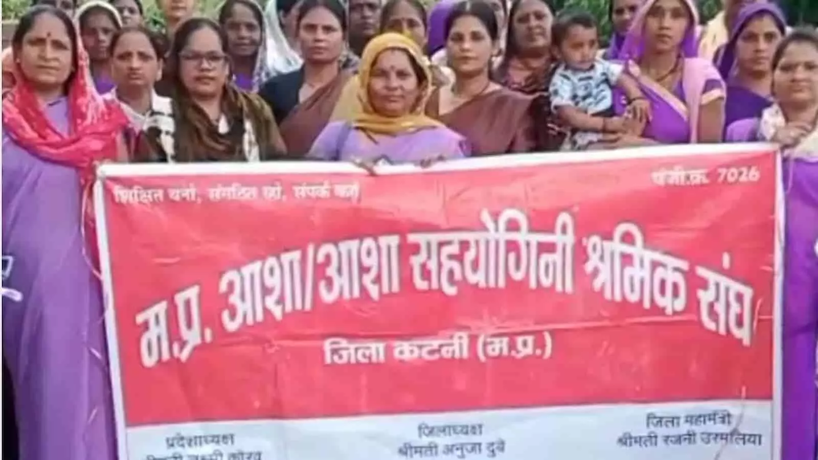 तस्वीर में कटनी कलेक्ट्रेट पर प्रदर्शन के दौरान लाल बैनर थामे खड़ी आशा कार्यकर्ता।