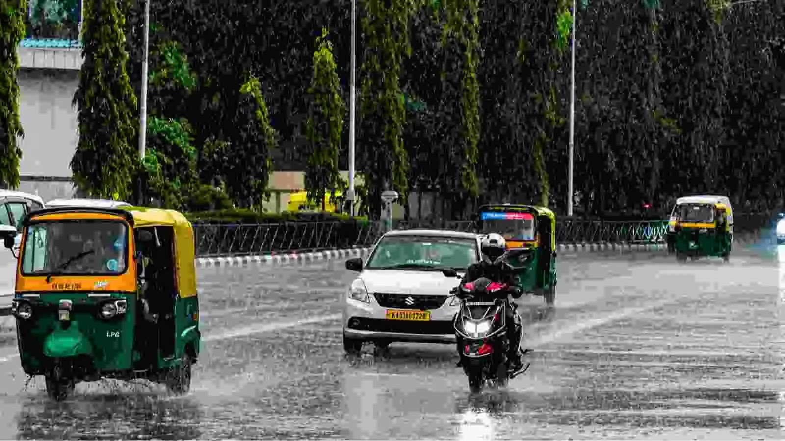 सड़कों पर बारिश के दौरान चल रहे वाहन केरल और कर्नाटक में मानसूनी वर्षा के संदर्भ में।