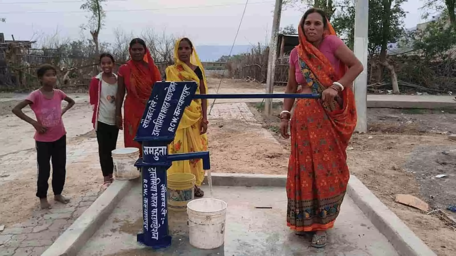 रोहतास में गांव की महिलाएं और बच्चे नए हैंडपंप के पास खड़े हैं।
