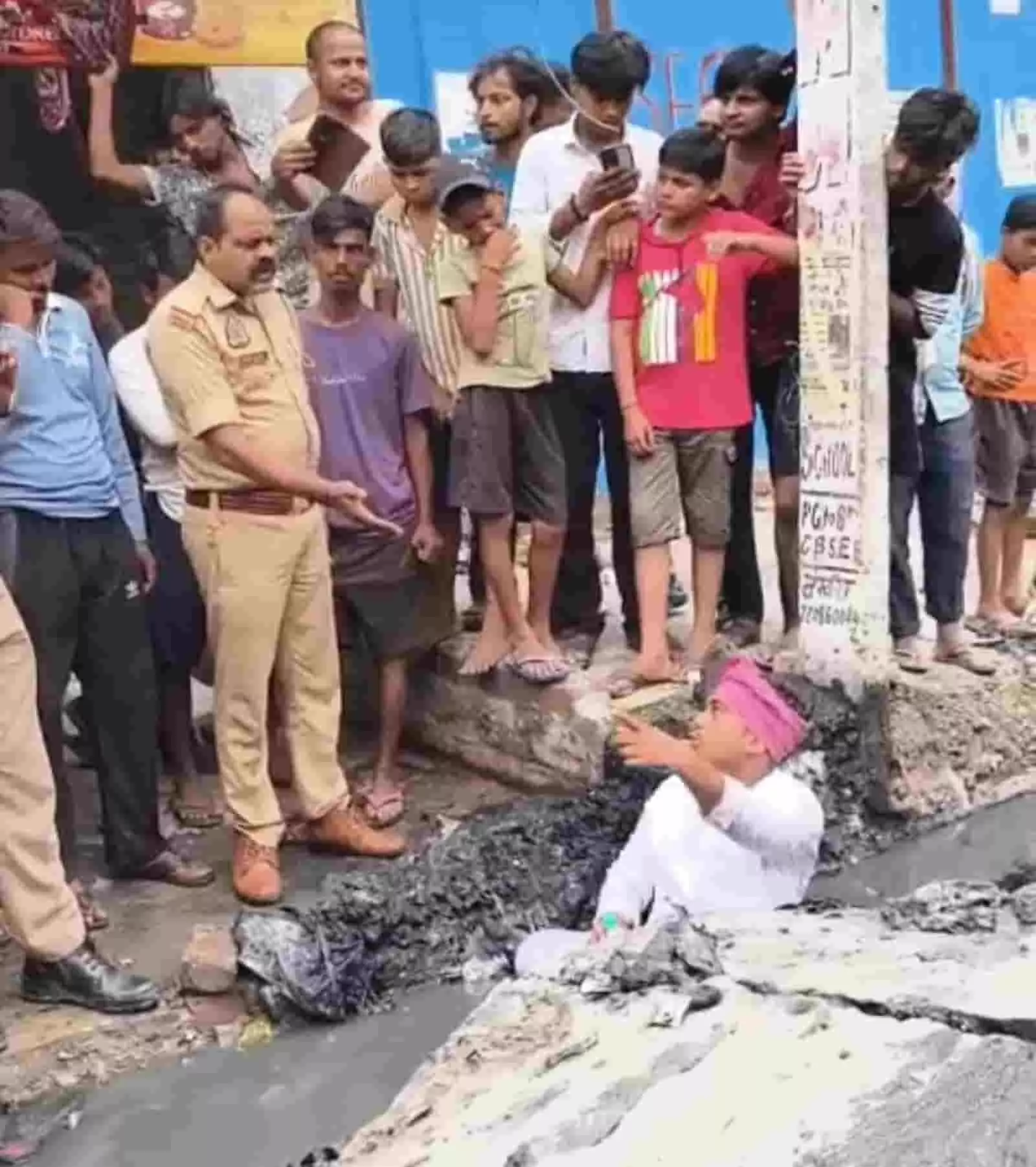 चंदौली में नाले के भीतर बैठे प्रदर्शनकारी युवक को समझाते पुलिस अधिकारी और भीड़। चंदौली में नाले के भीतर बैठे प्रदर्शनकारी युवक को समझाते पुलिस अधिकारी और भीड़।