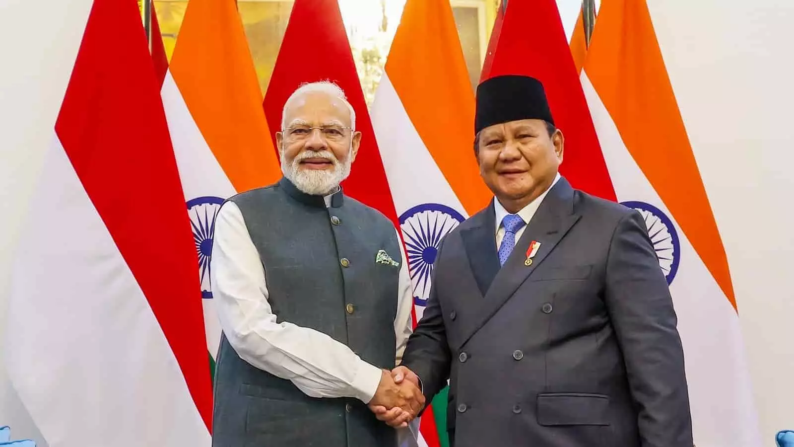 तस्वीर में प्रधानमंत्री नरेंद्र मोदी और इंडोनेशिया के राष्ट्रपति हाथ मिलाते हुए दिख रहे हैं।