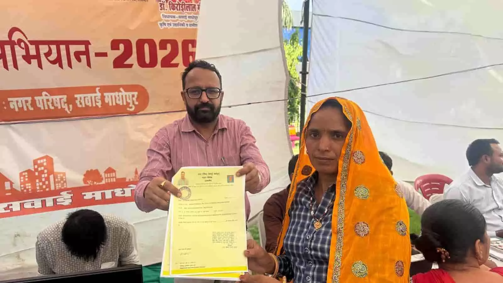 तस्वीर में नगर परिषद आयुक्त सवाई माधोपुर के शिविर में महिला को पट्टा दस्तावेज सौंप रहे हैं। तस्वीर में नगर परिषद आयुक्त सवाई माधोपुर के शिविर में महिला को पट्टा दस्तावेज सौंप रहे हैं।