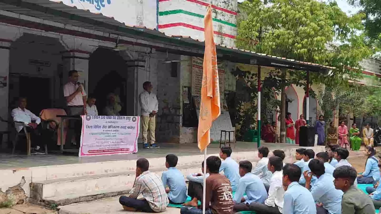 स्कूल परिसर में विधिक जागरूकता शिविर के दौरान मंच से बोलते अधिकारी और सुनते छात्र। स्कूल परिसर में विधिक जागरूकता शिविर के दौरान मंच से बोलते अधिकारी और सुनते छात्र।